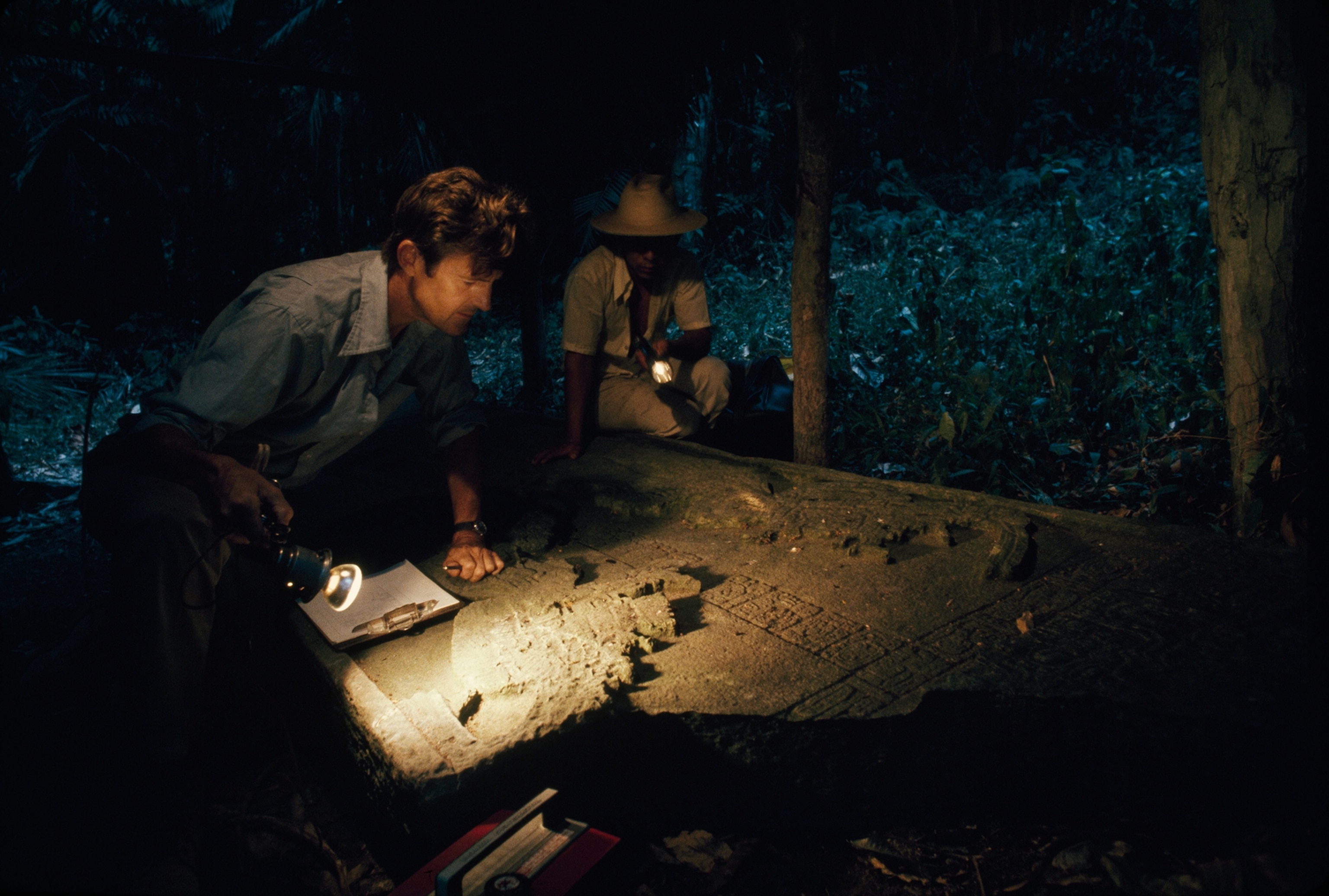 Seeking keys to the past, Ian Graham plays lights across eroded details of a stela at Yaxchilán, Meico.