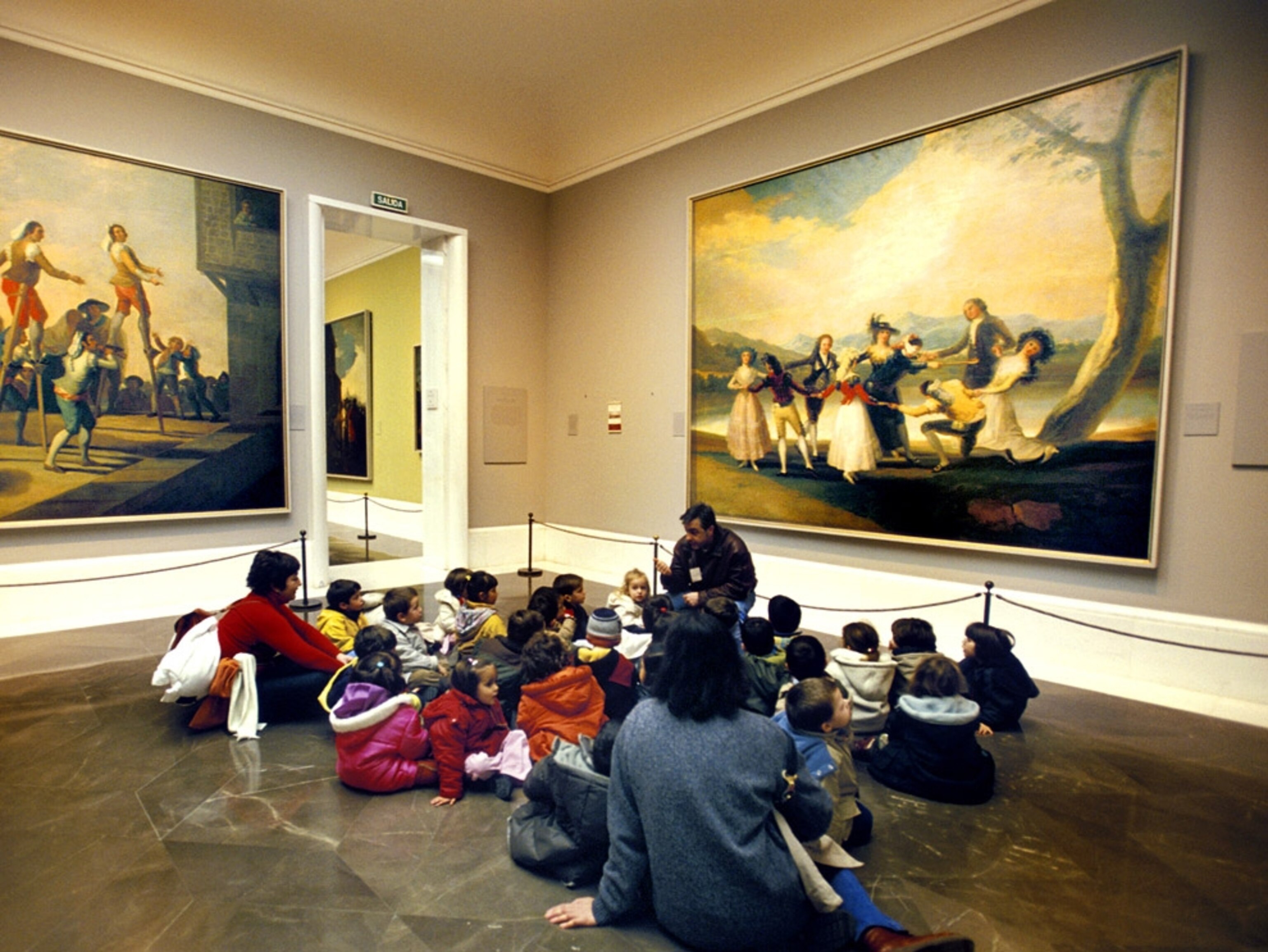 Children sitting on the floor of a museum hall