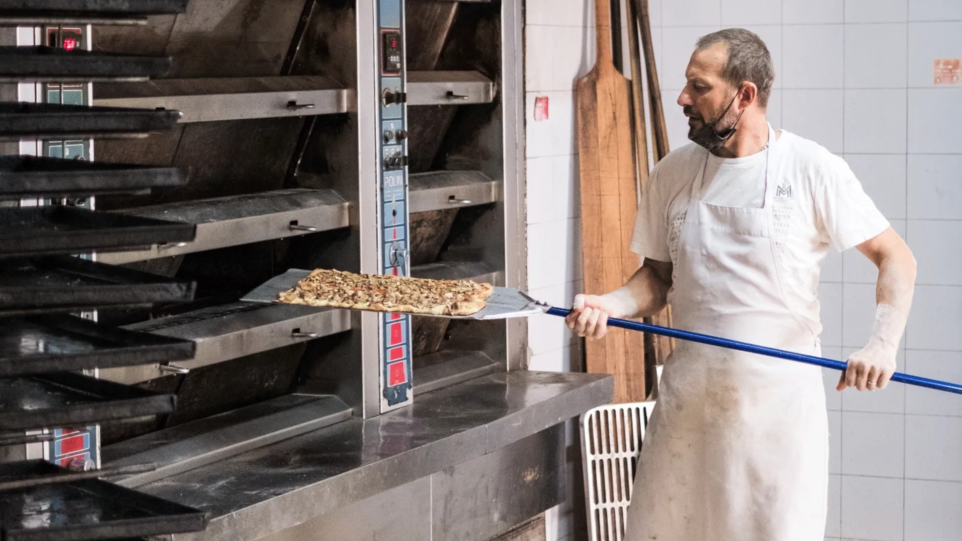 At Panificio Passi, lengths of dimpled pizza bianca dough are baked throughout the day, before being brushed with oil, then sold by weight.