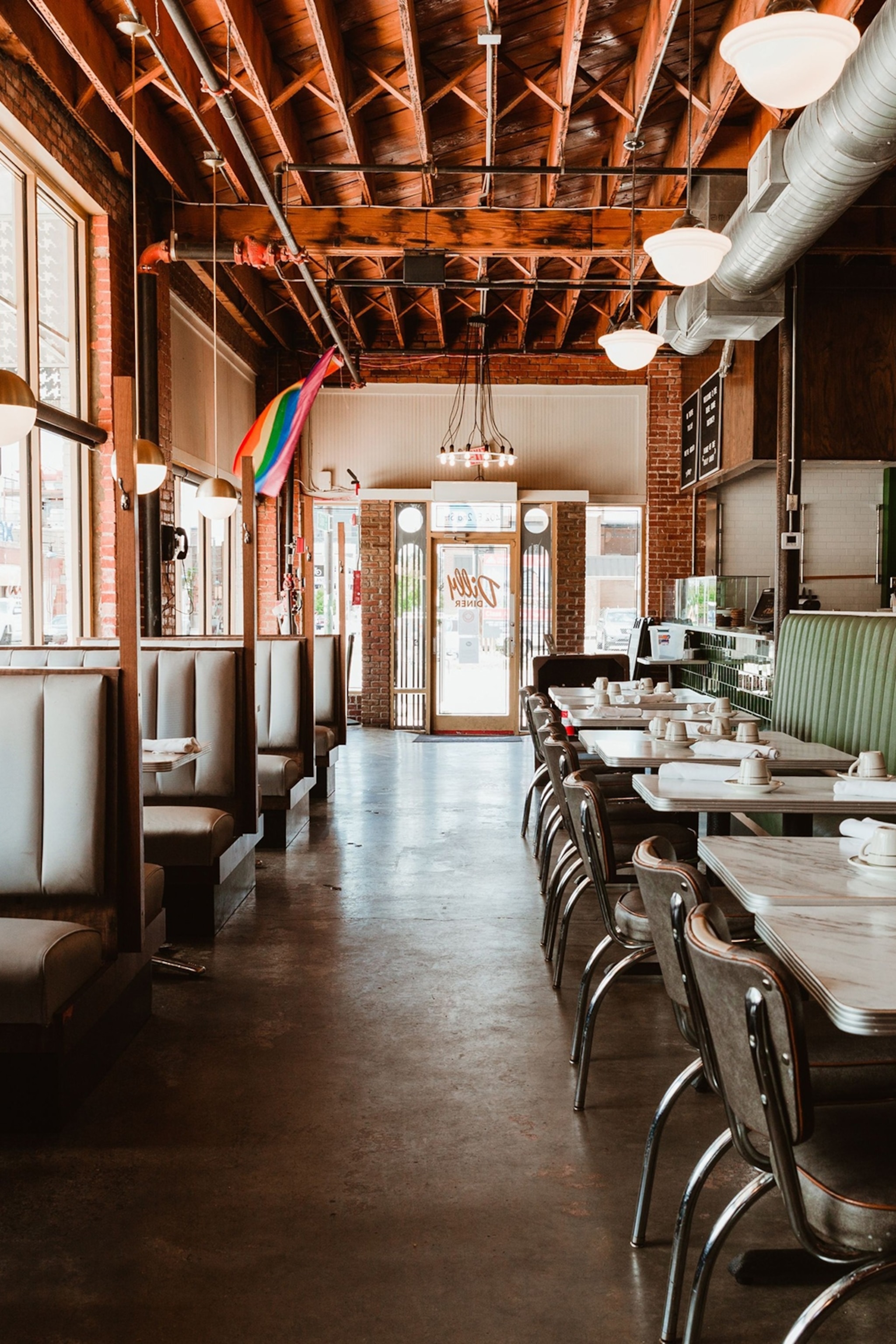 The interiors of a classic diner with booth tables and lots of windows.