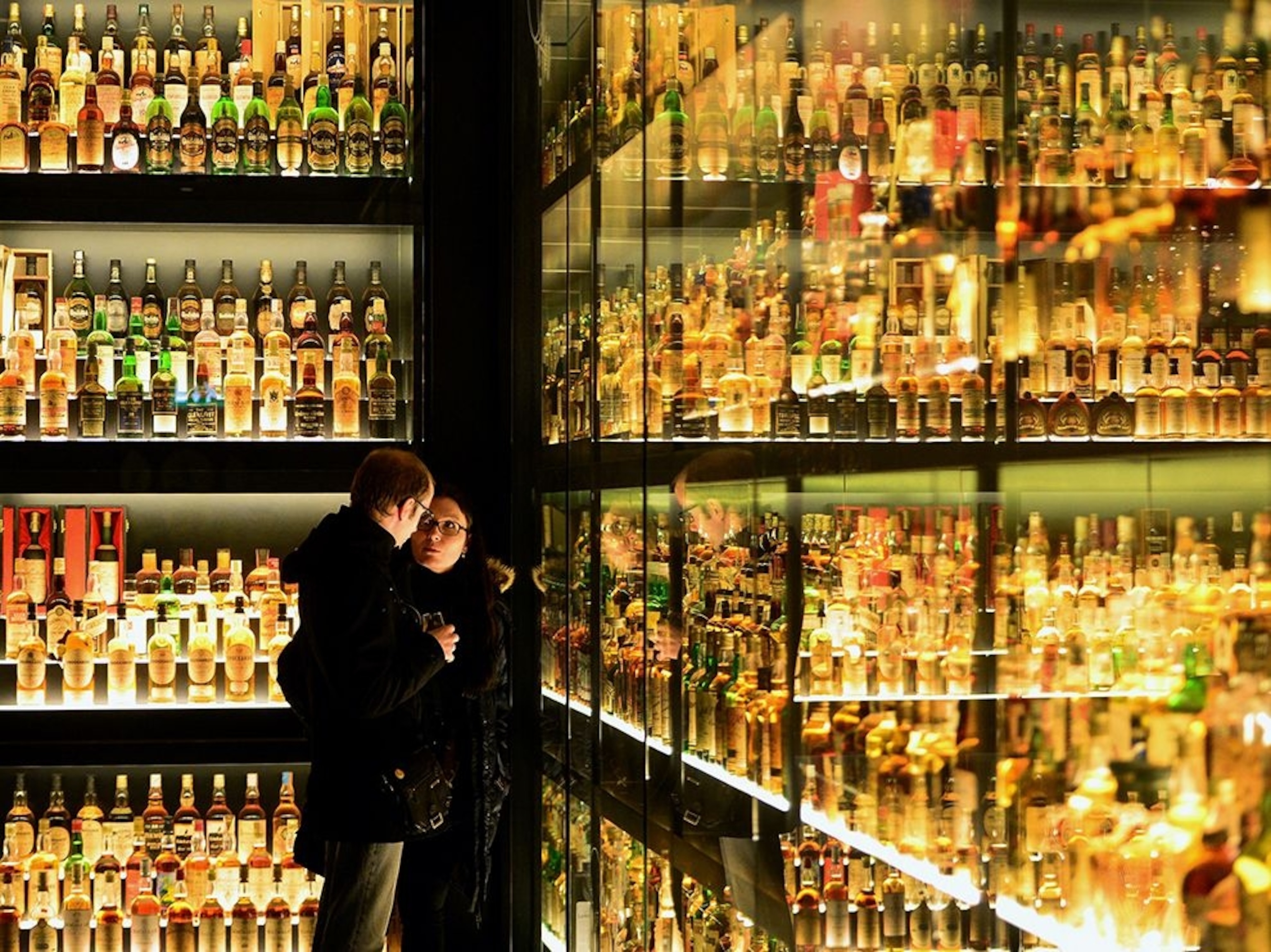 two people viewing a whisky collection, Edinburgh, Scotland