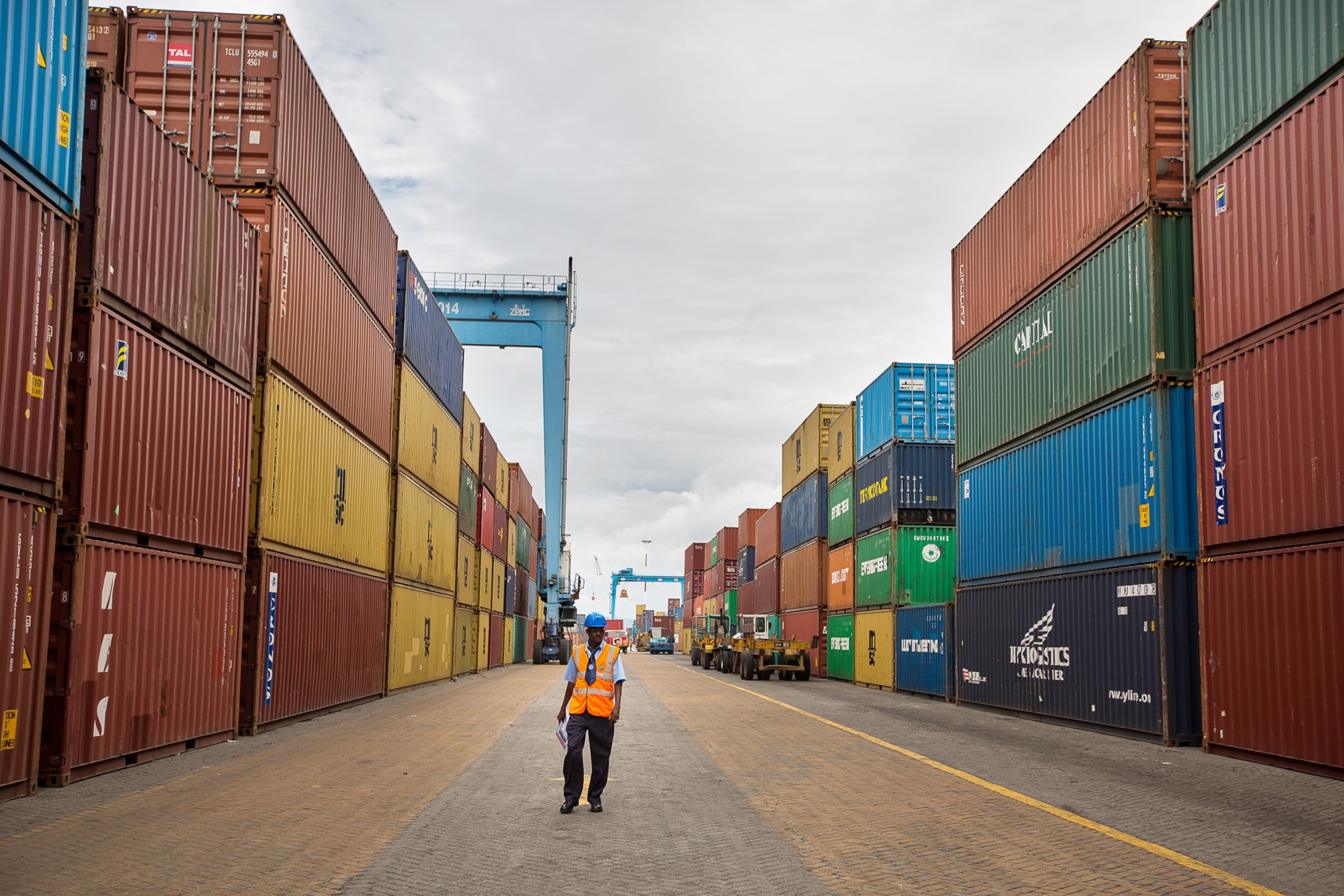 a dock worker for the Kenya Ports Authority standing amid rows of shipping containers.