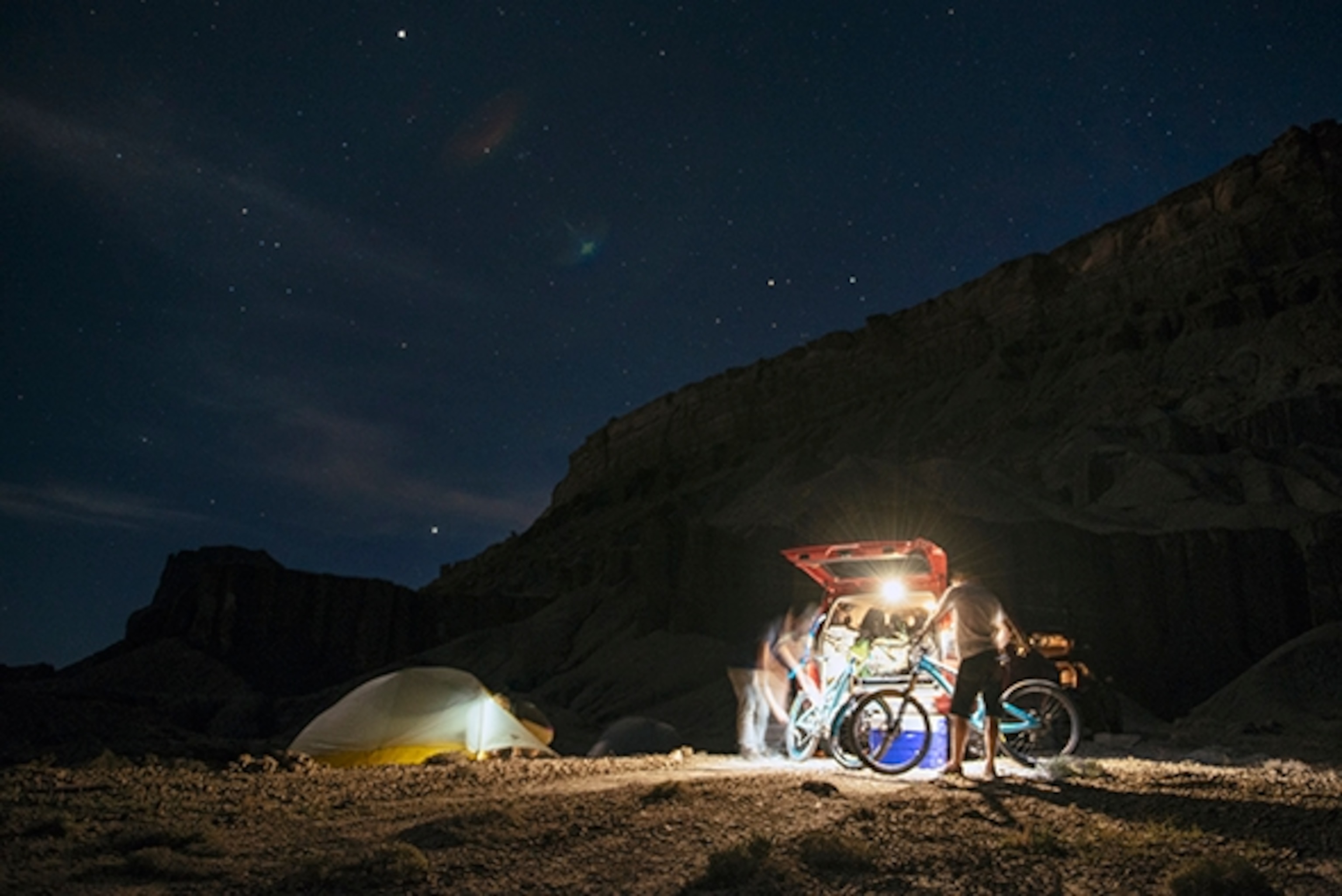 Carston Oliver and Joey Schusler prep their bikes for the morning ride by the light of our 4Runner at our camp at the Book Cliffs, Utah; Photograph by Max Lowe