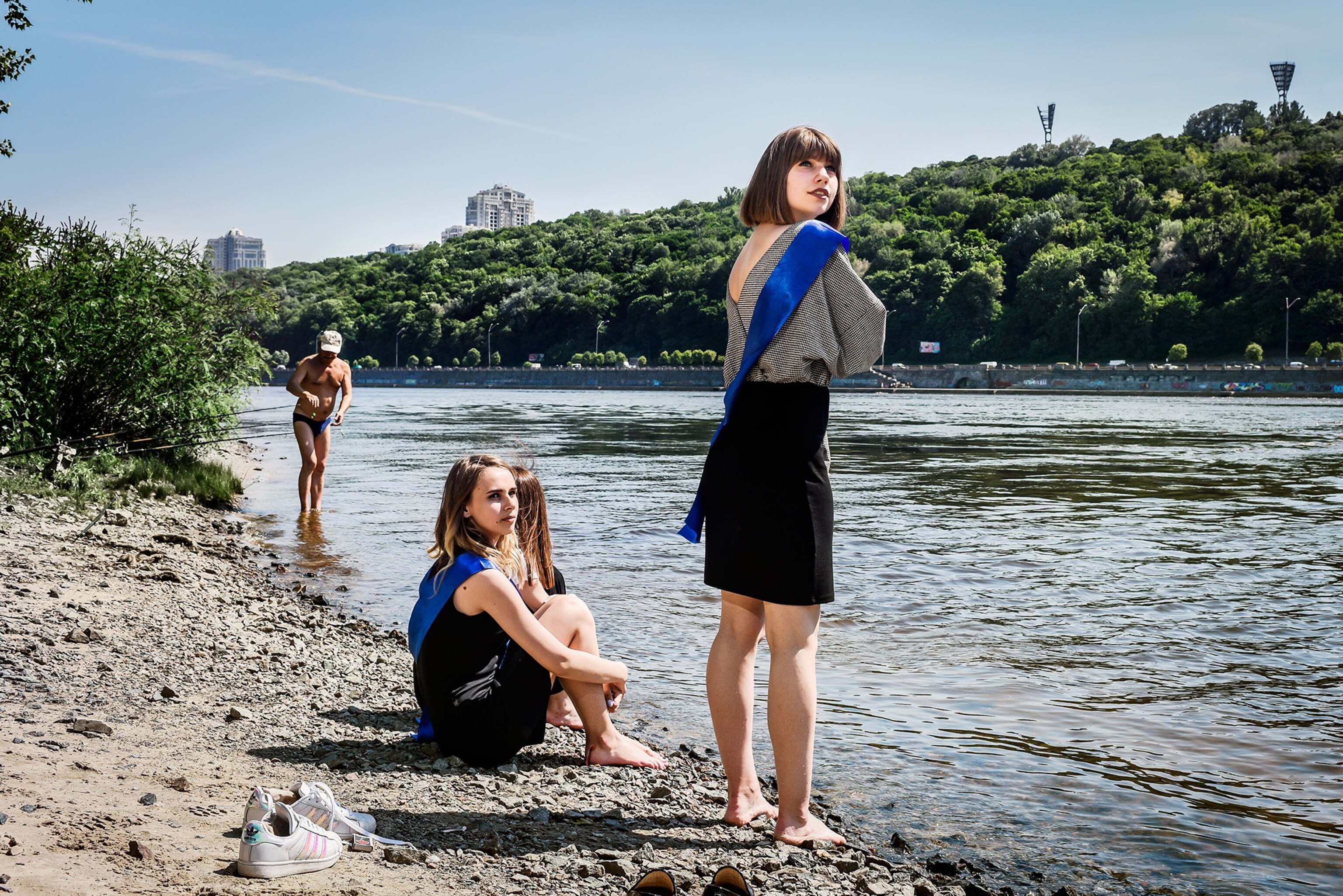students hanging by the Dnepr River after the last day of school in Kiev, Ukraine
