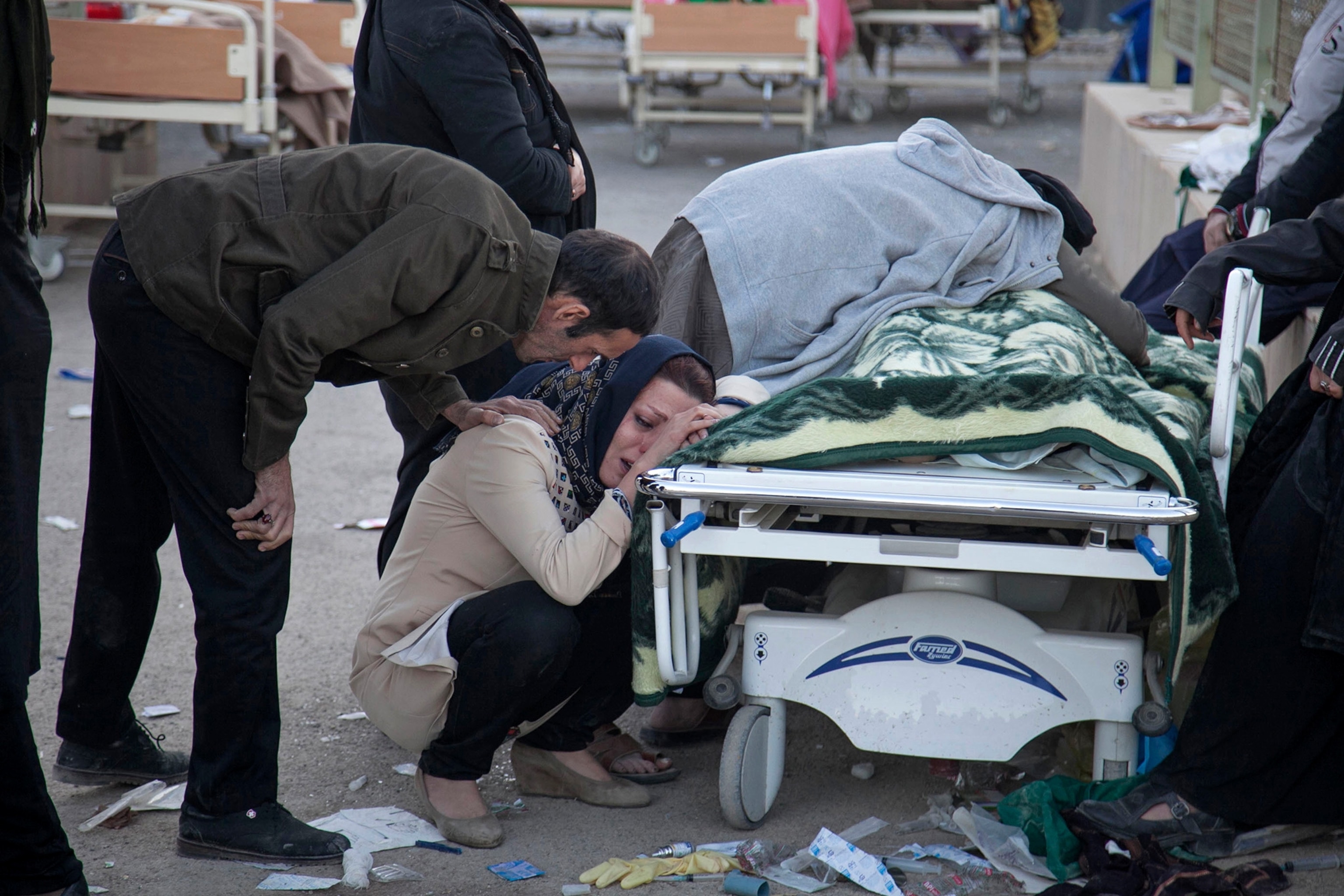 family members crying over a body of an earthquake victim