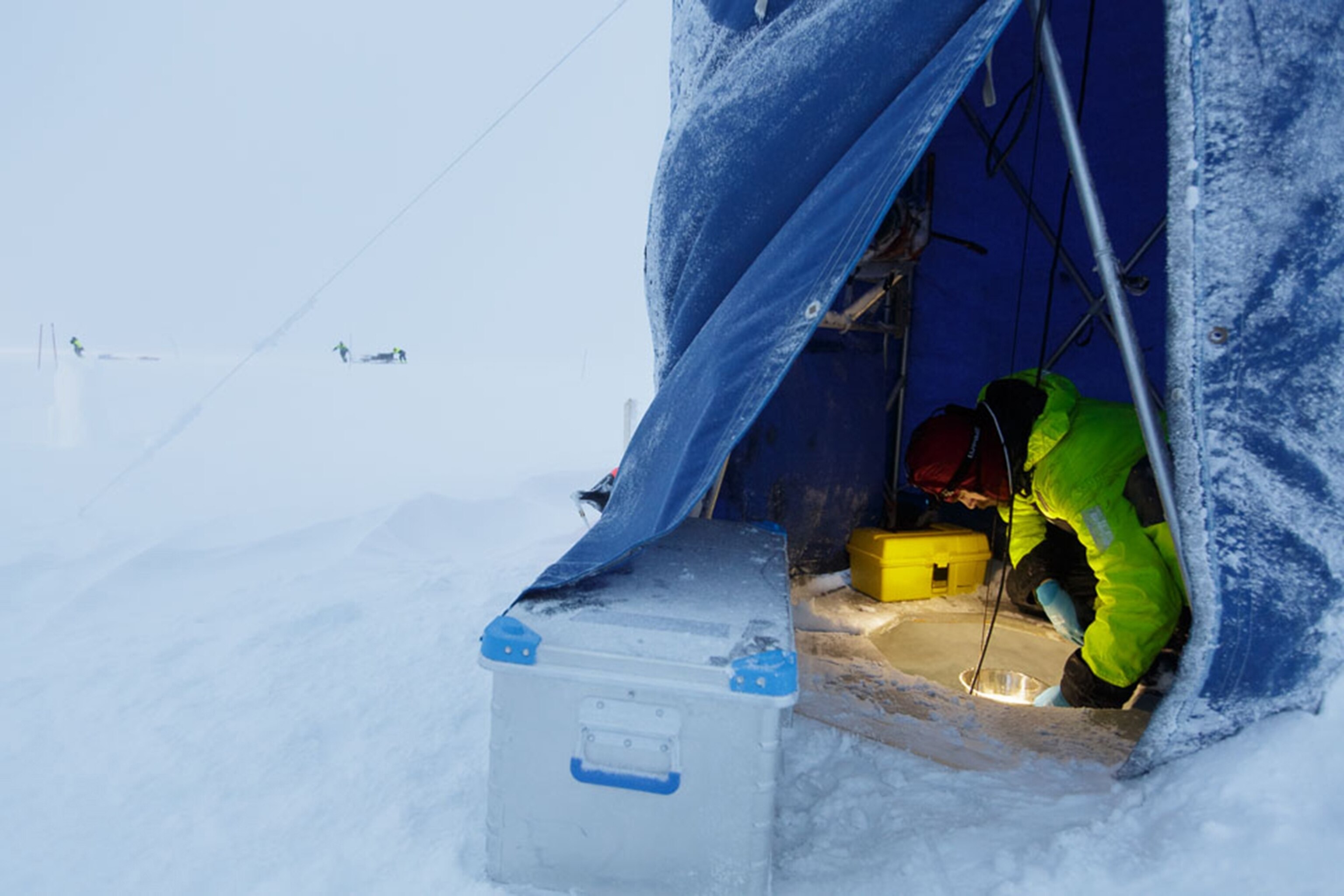 Algot Peterson maintaining a hole through the sea ice