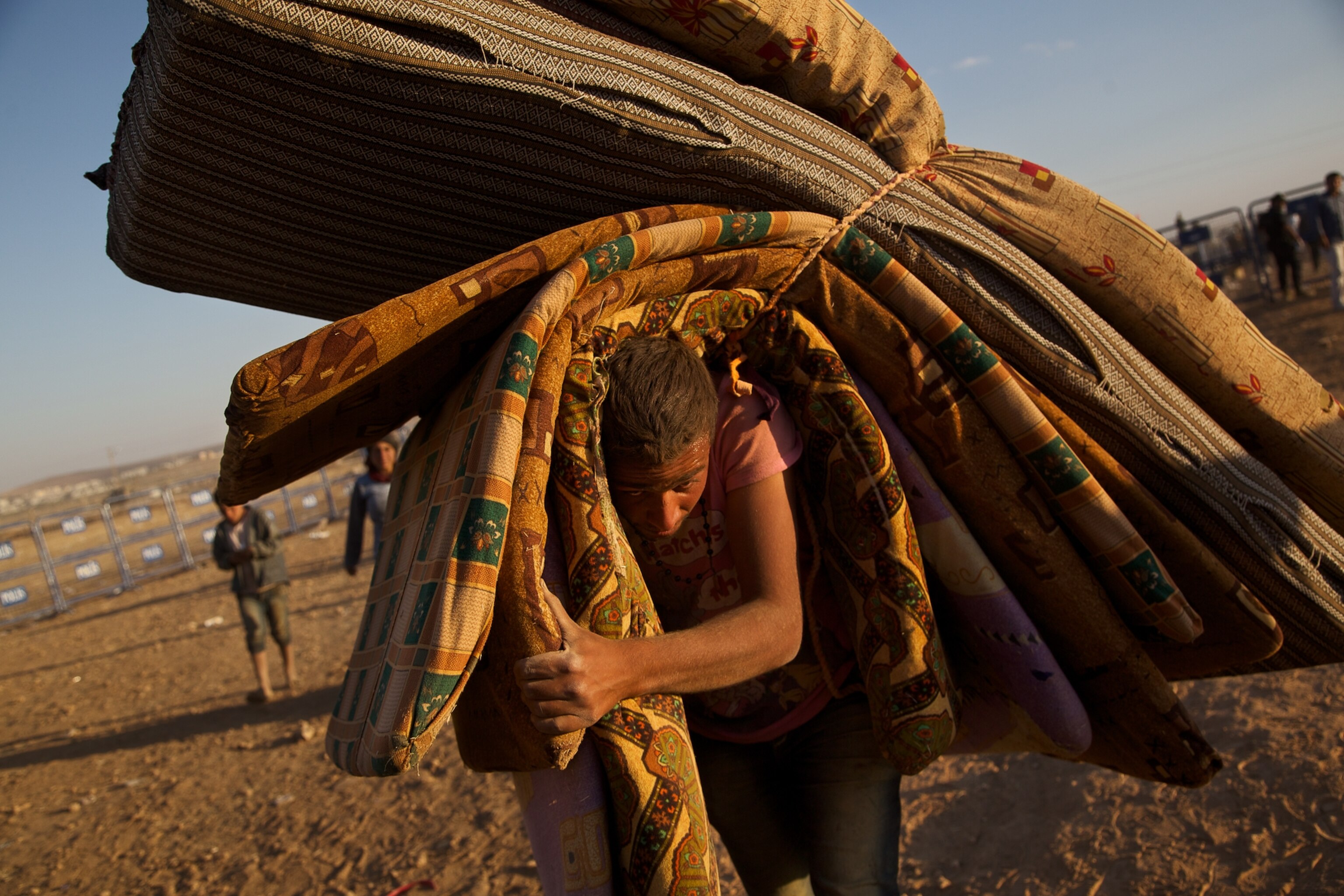 a Syrian women carrying a baby after fleeing to Turkey with thousands of others.