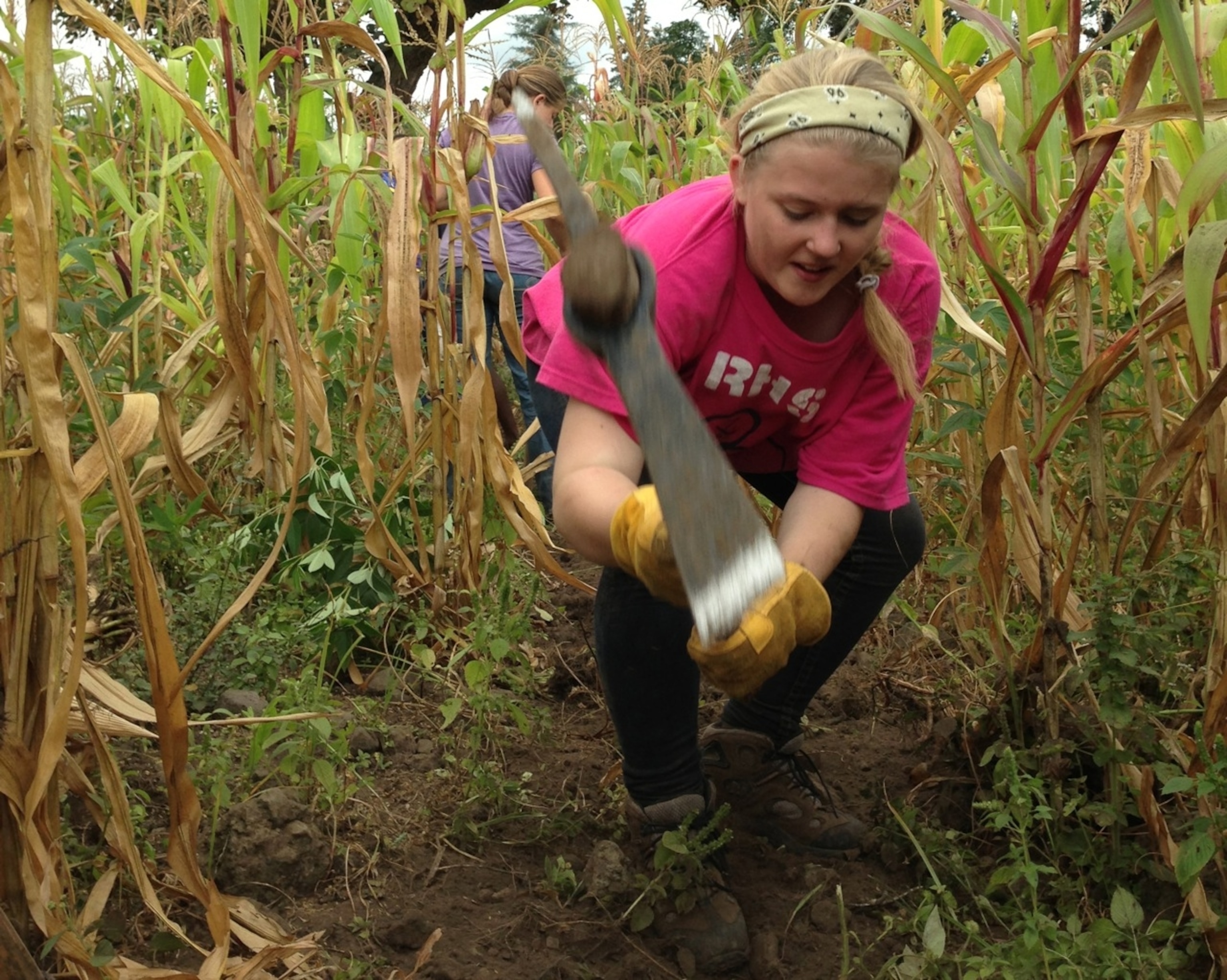 National Geographic Student Katie Burns smashes rocks with a pickaxe as part of our community service project in Maji ya Chai, Tanzania. (Photo by Andrew Evans, National Geographic Traveler)