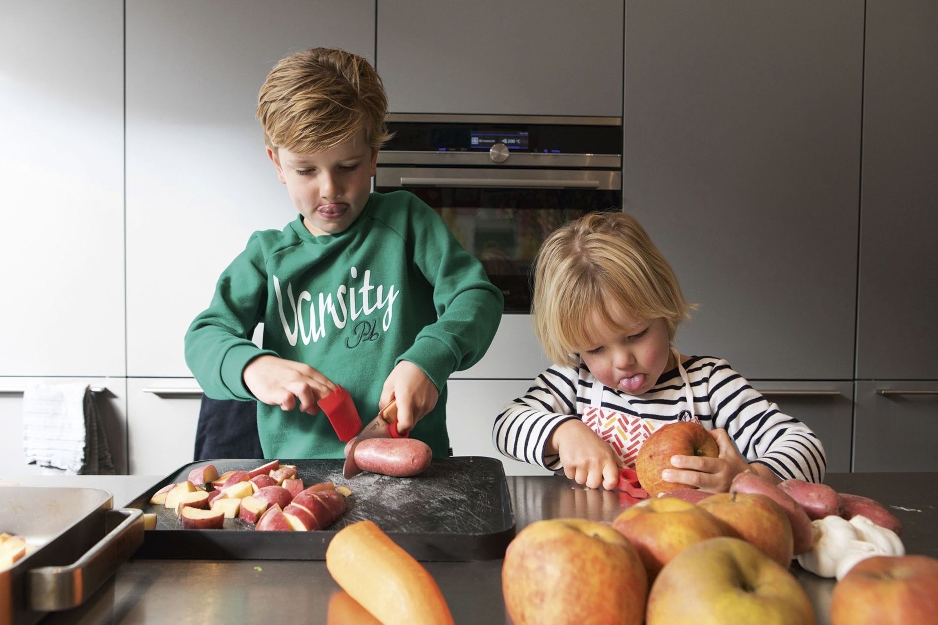 The children slice fruit and vegetables.