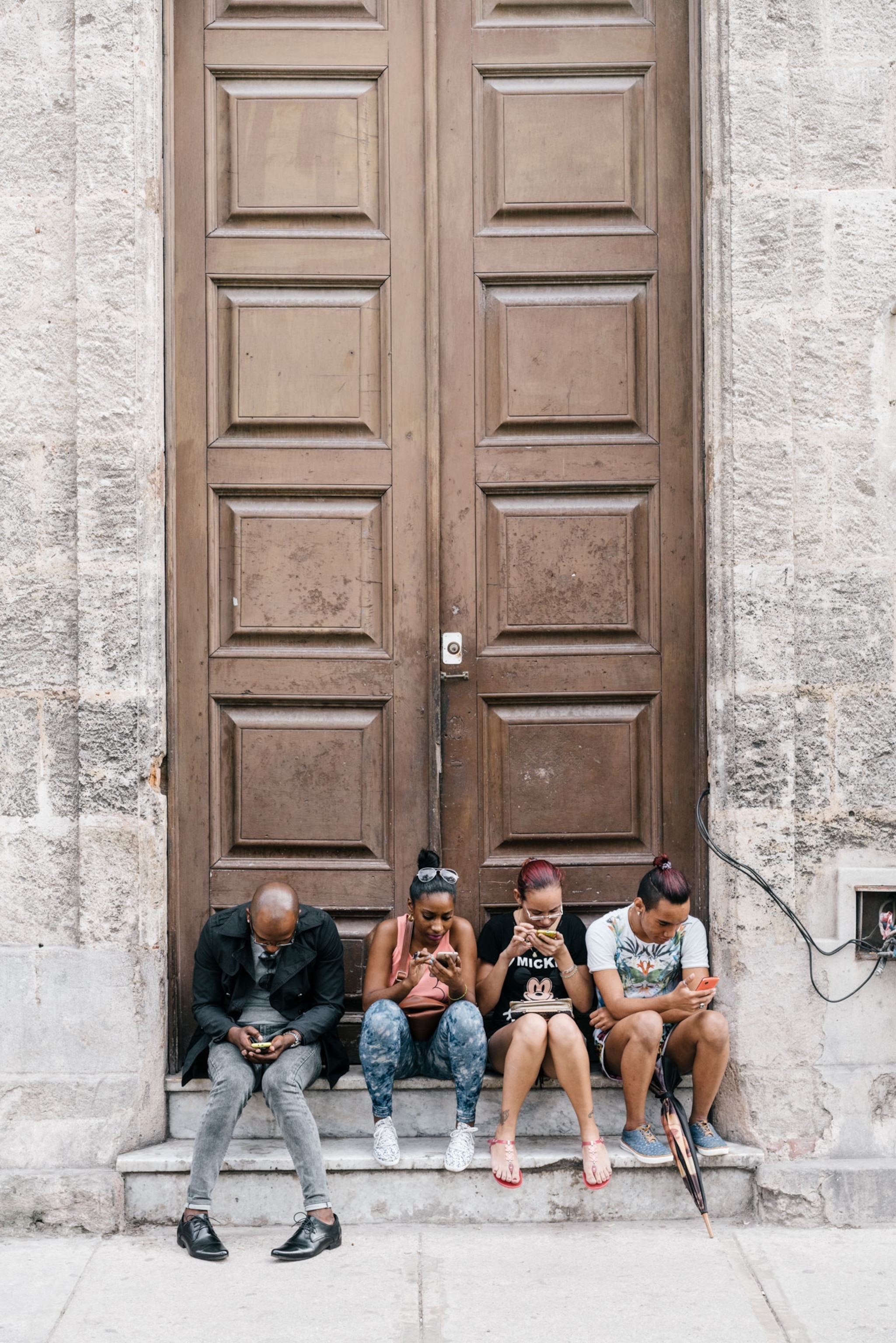 people on their phones in Havana, Cuba