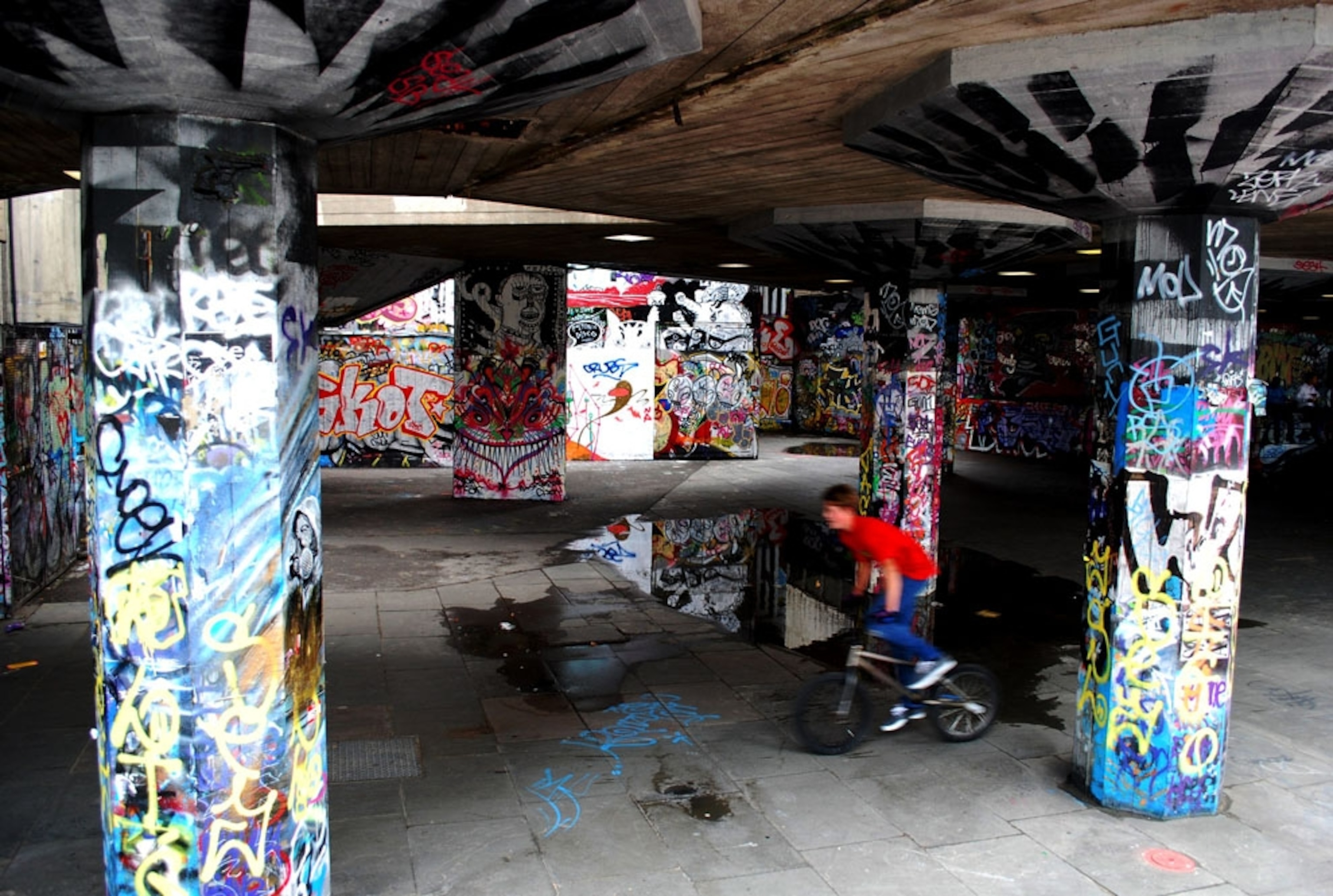 A cyclist riding around a graffiti-covered area