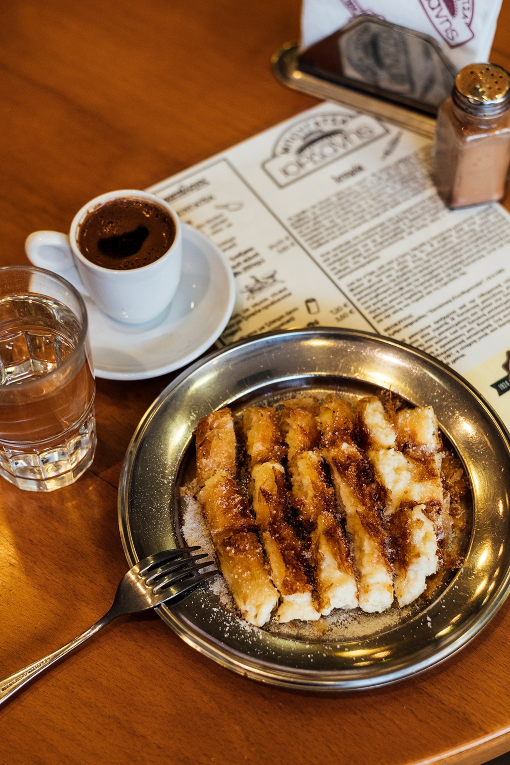 A breakfast spread of pastries, coffee and water.