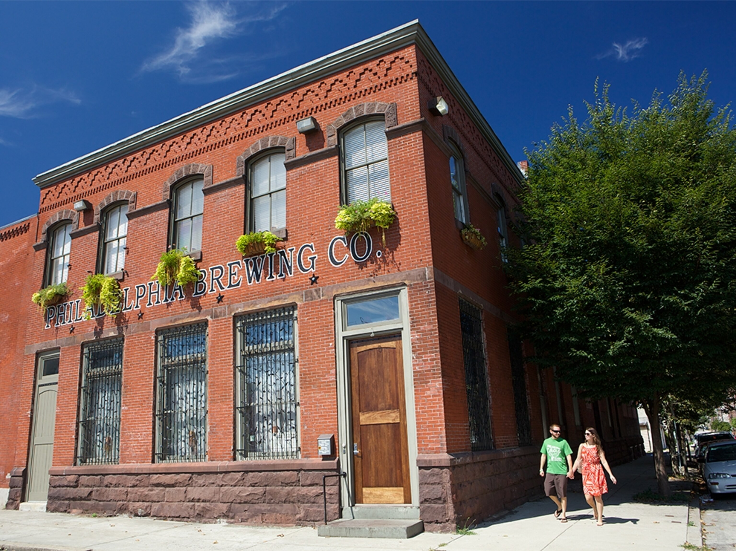 a couple walking past the Philadelphia Brewing Company