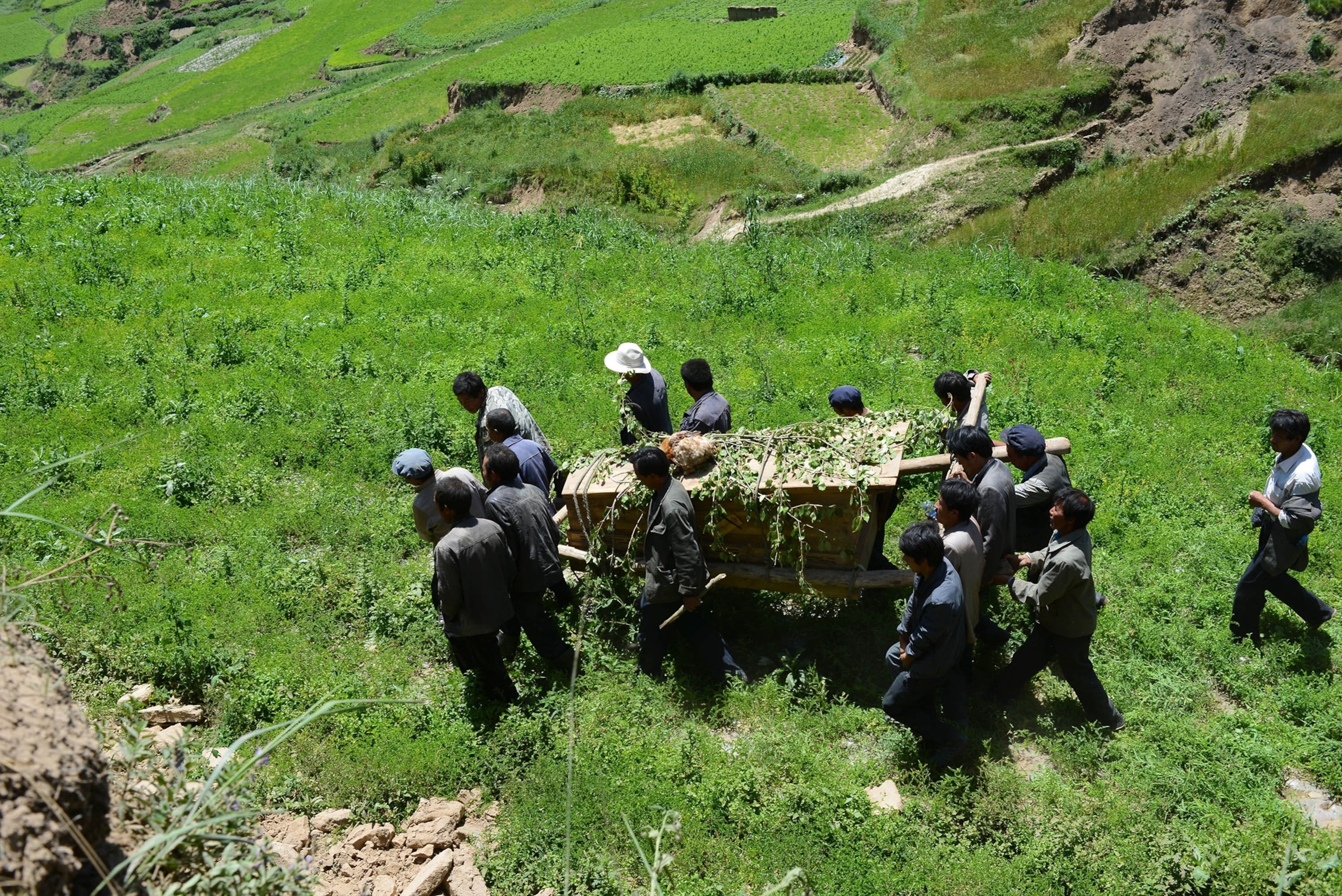 people carrying a coffin of an earthquake victim
