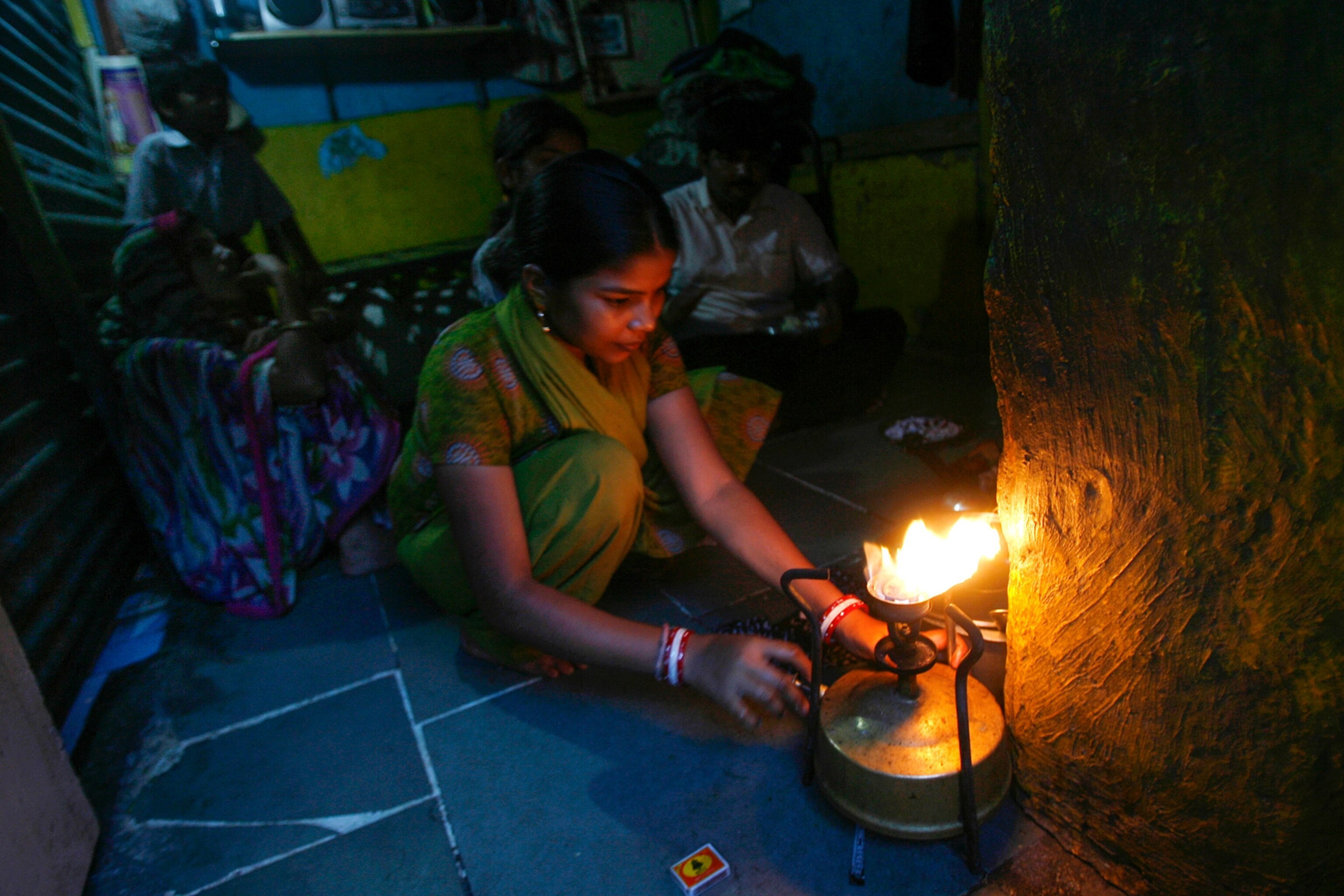 a woman cooking food in her shanty in Mumbai.