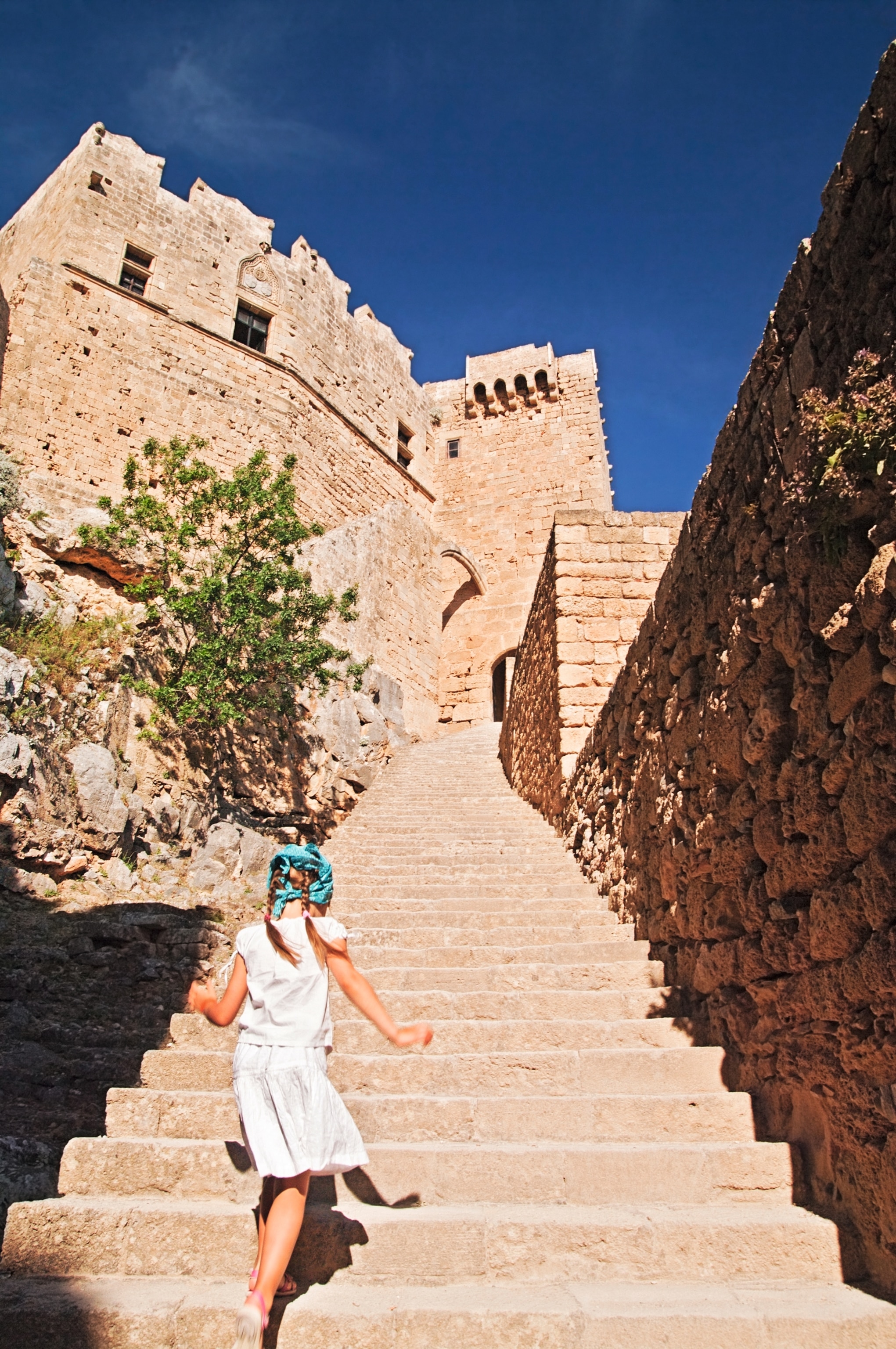 Little girl running up the stairs to the Lindos Acropolis.
