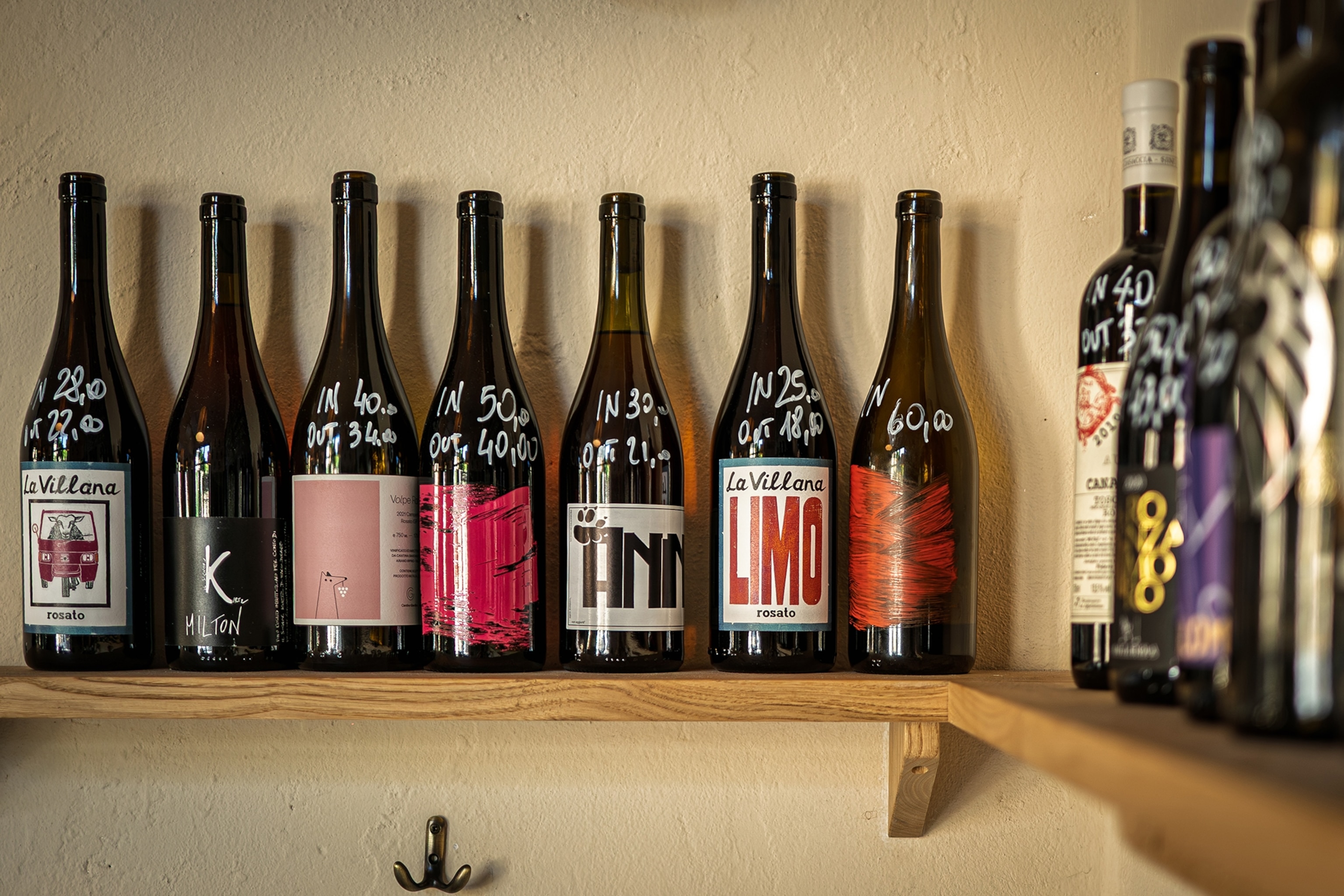 A wooden shelf lined with a variety of wine bottles.