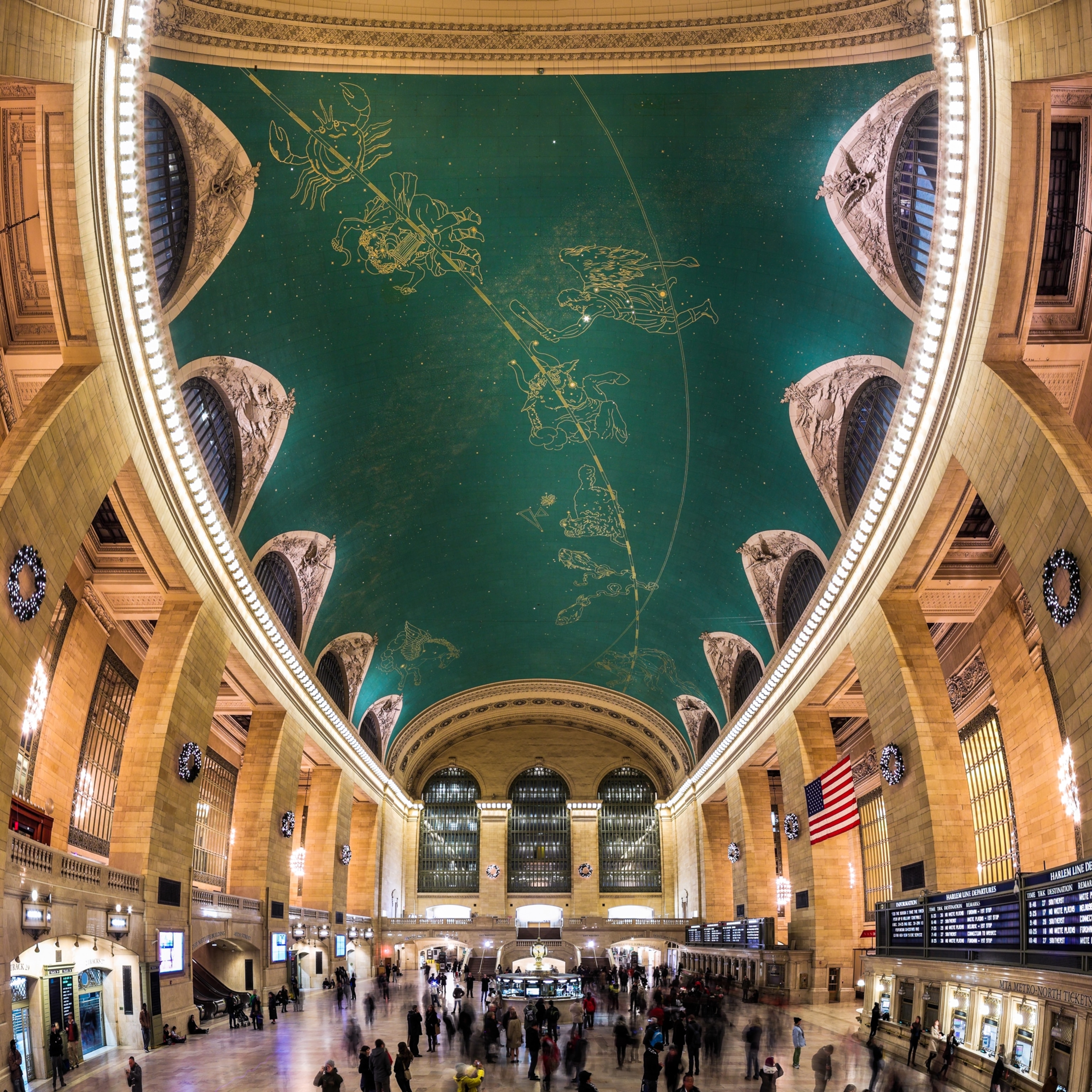 Grand Central Terminal's main concourse with its iconic domed ceiling featuring a celestial mural.