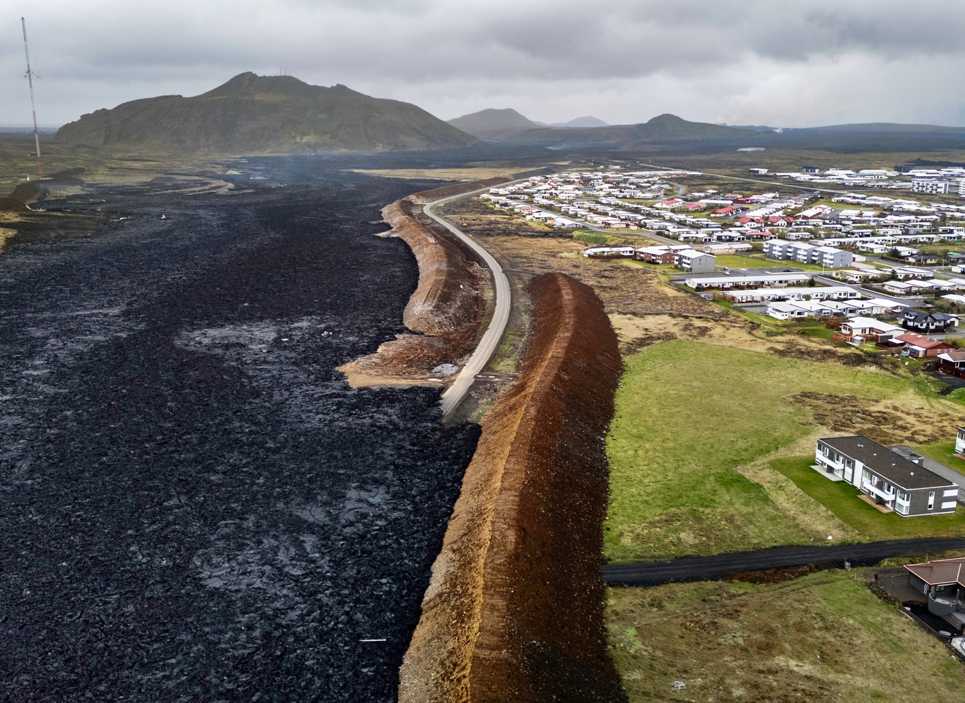 Aerial view of a town and protective walls made of dirt looking like dunes.