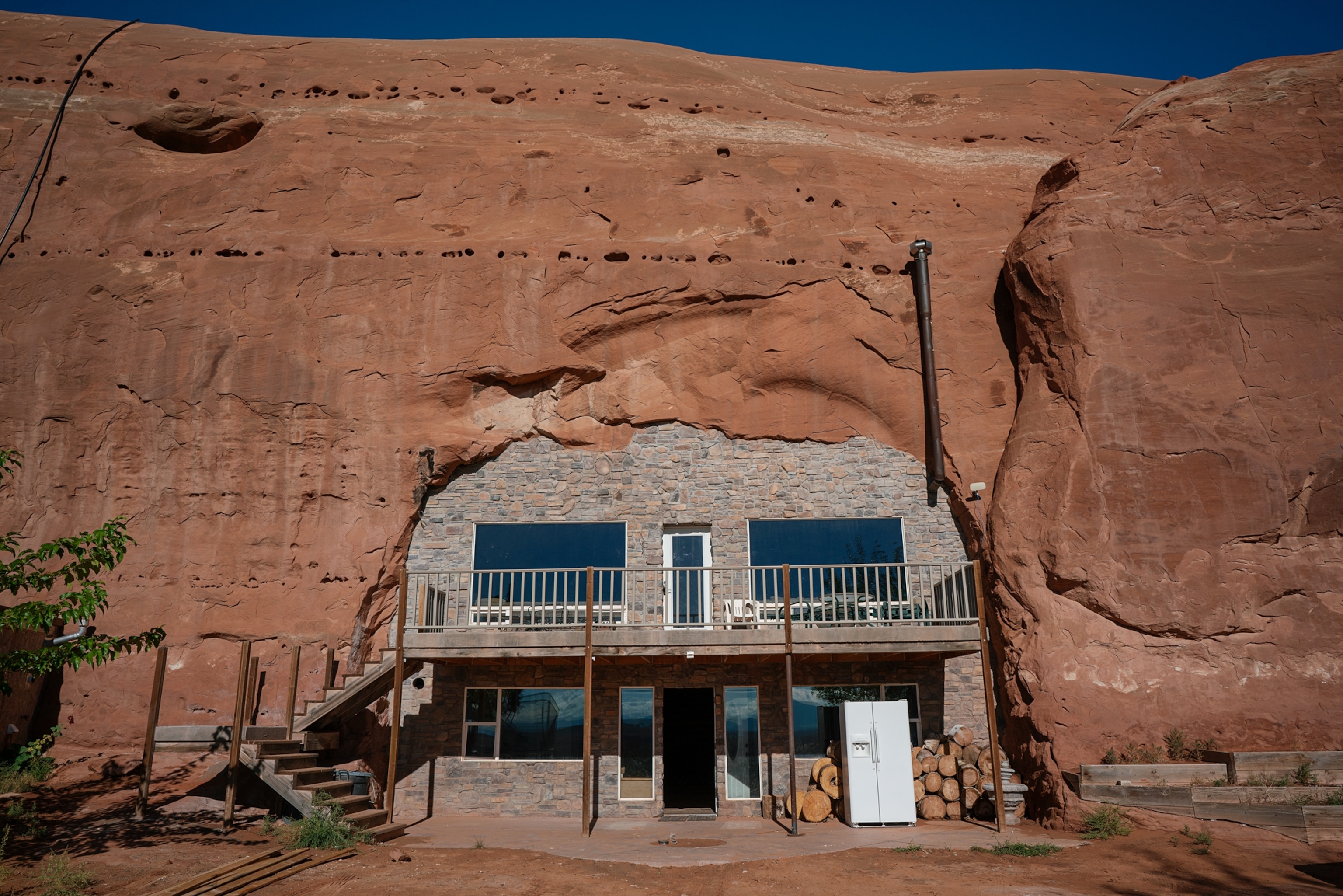 The front of a house is seen in the opening of a cave.