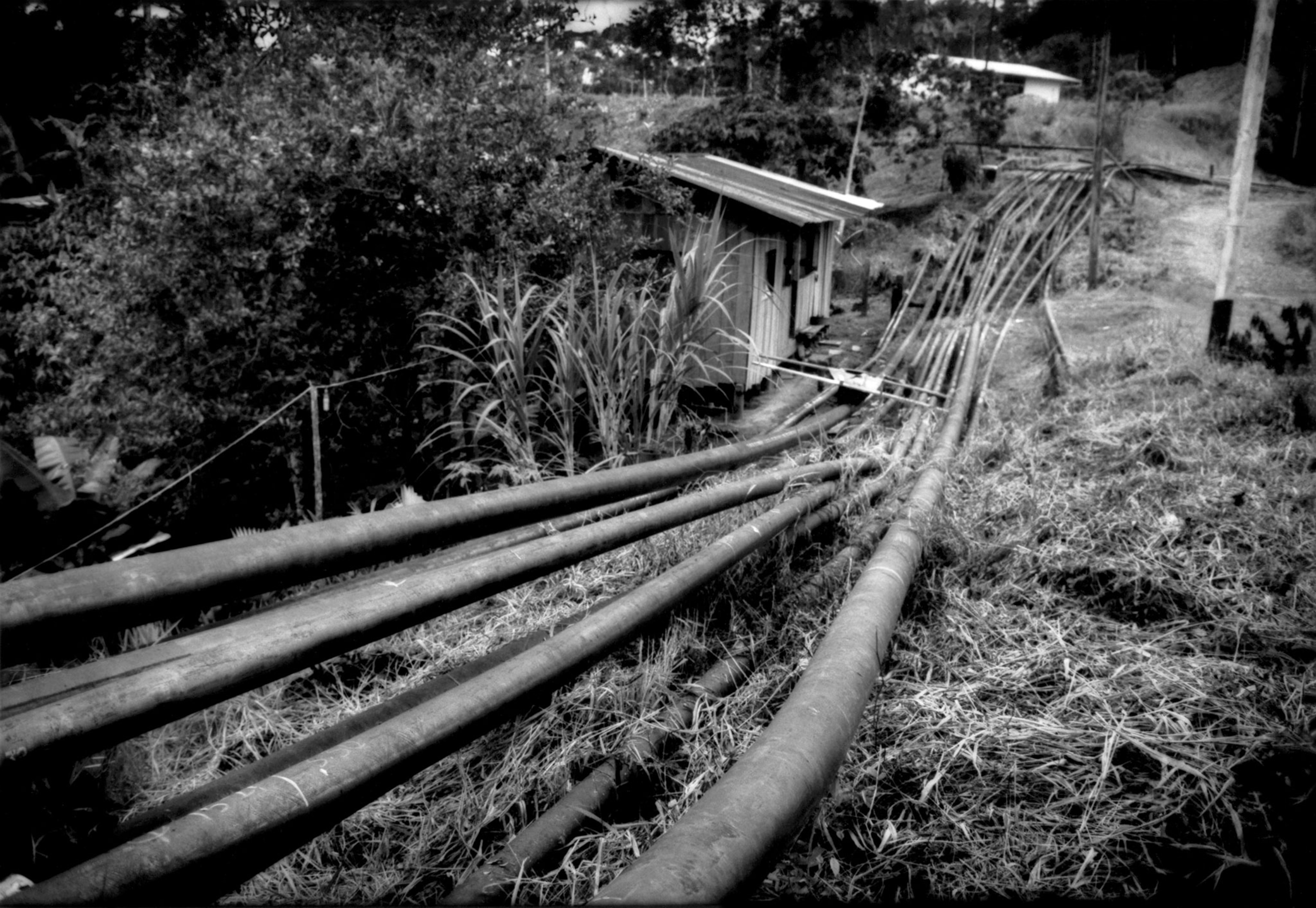 oil petroleum pipelines extending in front of a house in Ecuador