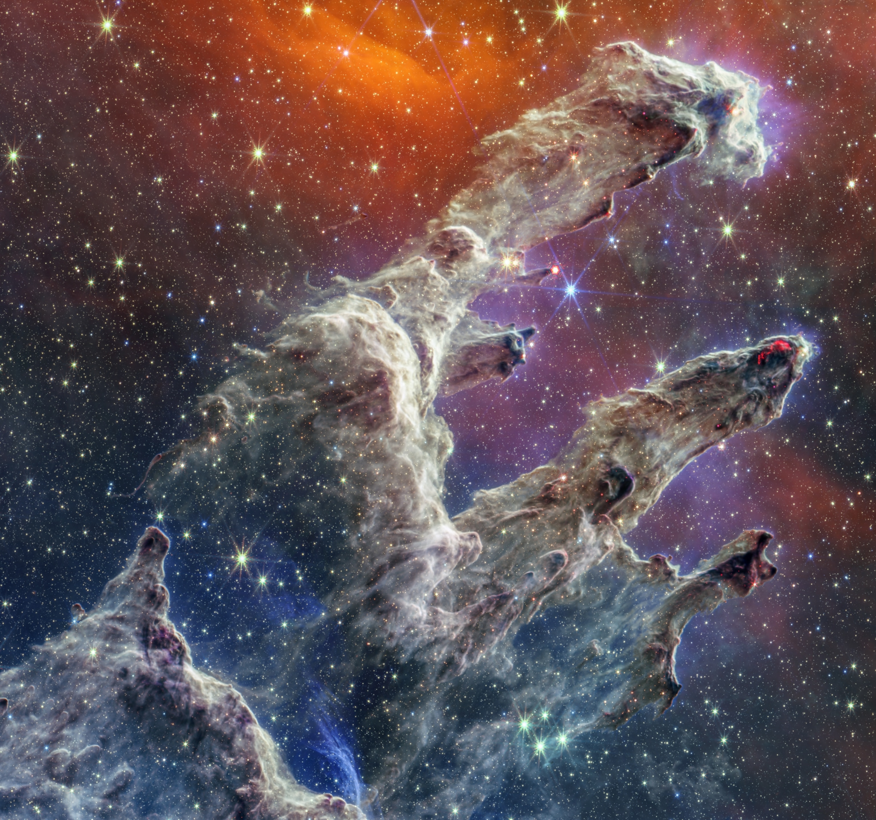 The Pillars of Creation, which appear as three enormous columns of dust and gas, dotted with millions of stars.