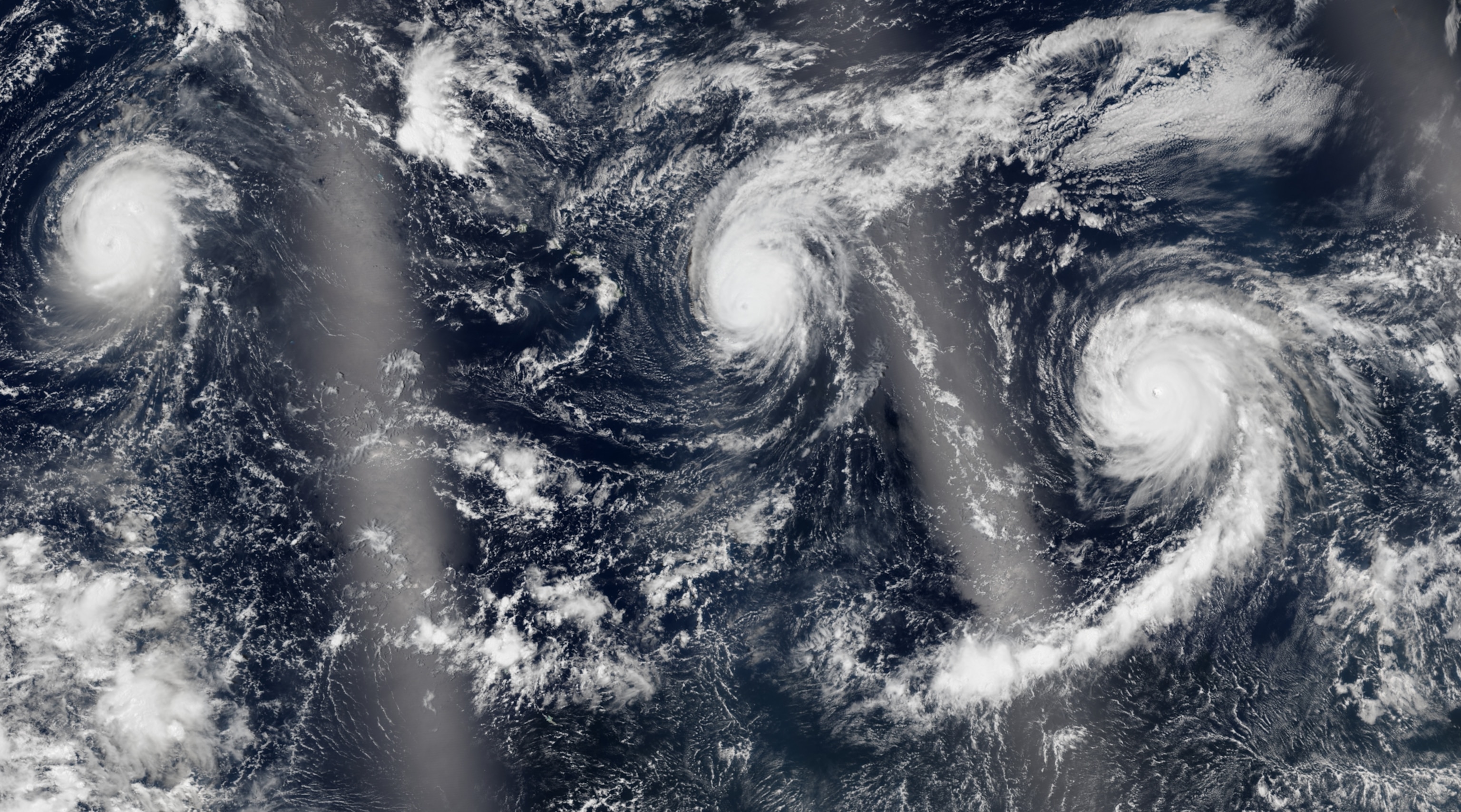 A satellite view of three swilling cyclones over the Pacific Ocean