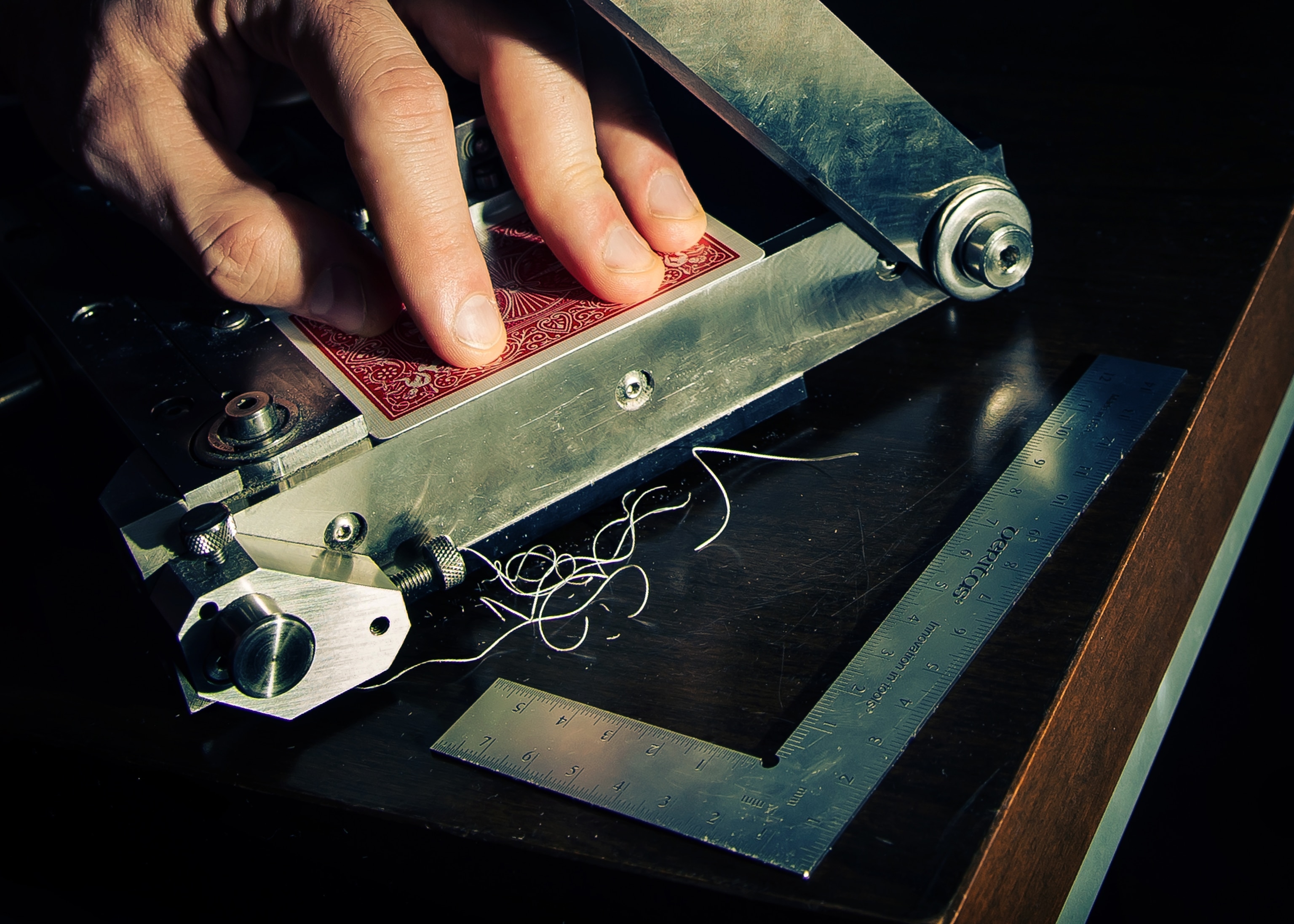 A magician shaves off tiny slivers of the edge of a playing card.