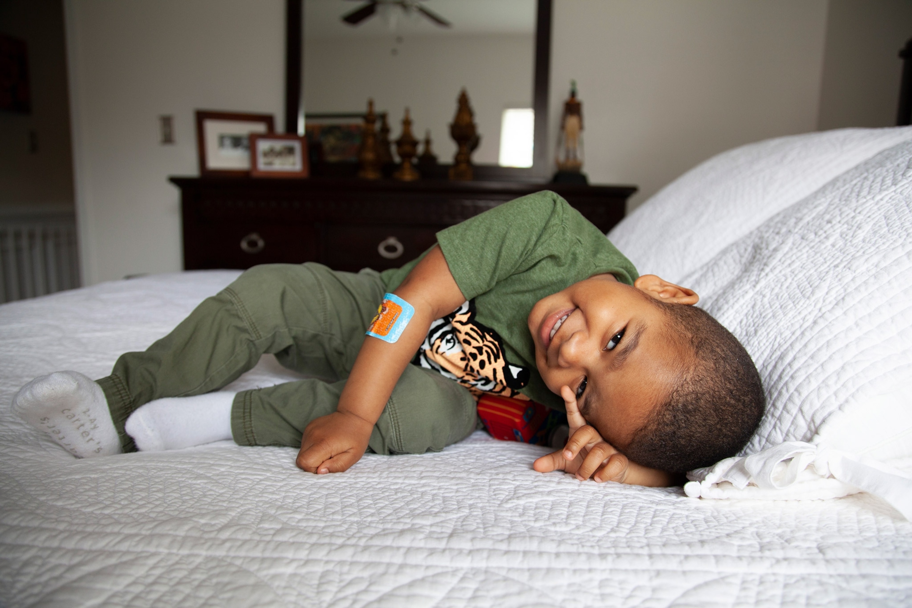 a little boy laughing on a bed