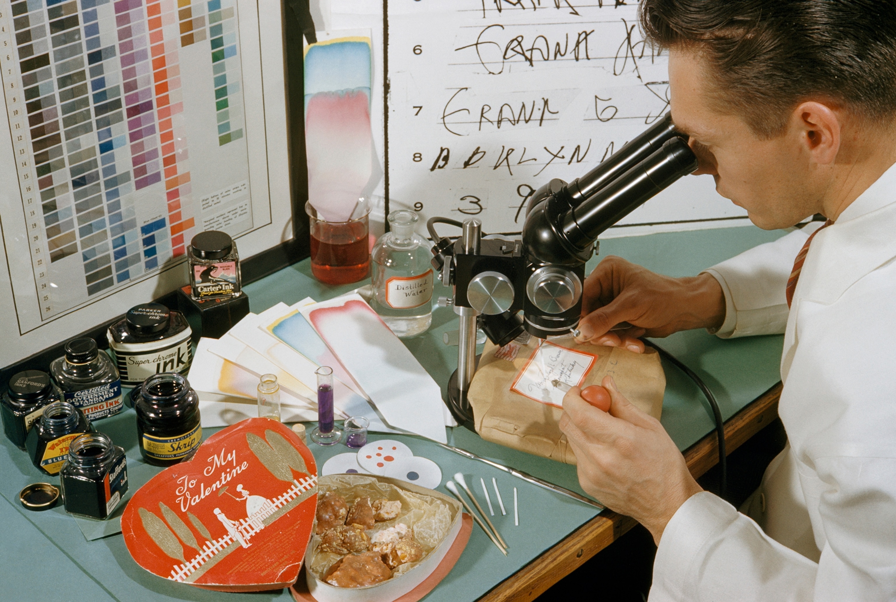A crime lab technician analyzes ink from a package of rat poison.