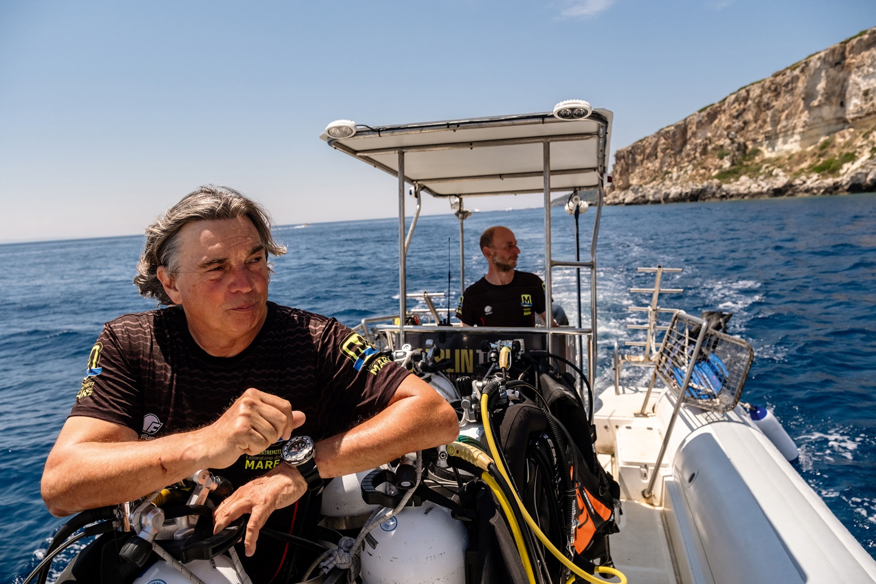 A middle-aged Italian man on a boat off the coast line of Puglia.