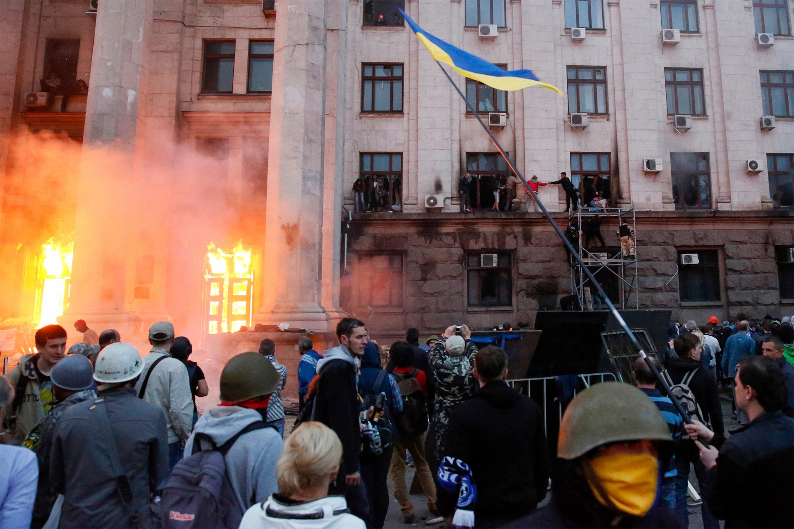 a pro-Russian activist aiming a pistol at supporters of the Kiev government.
