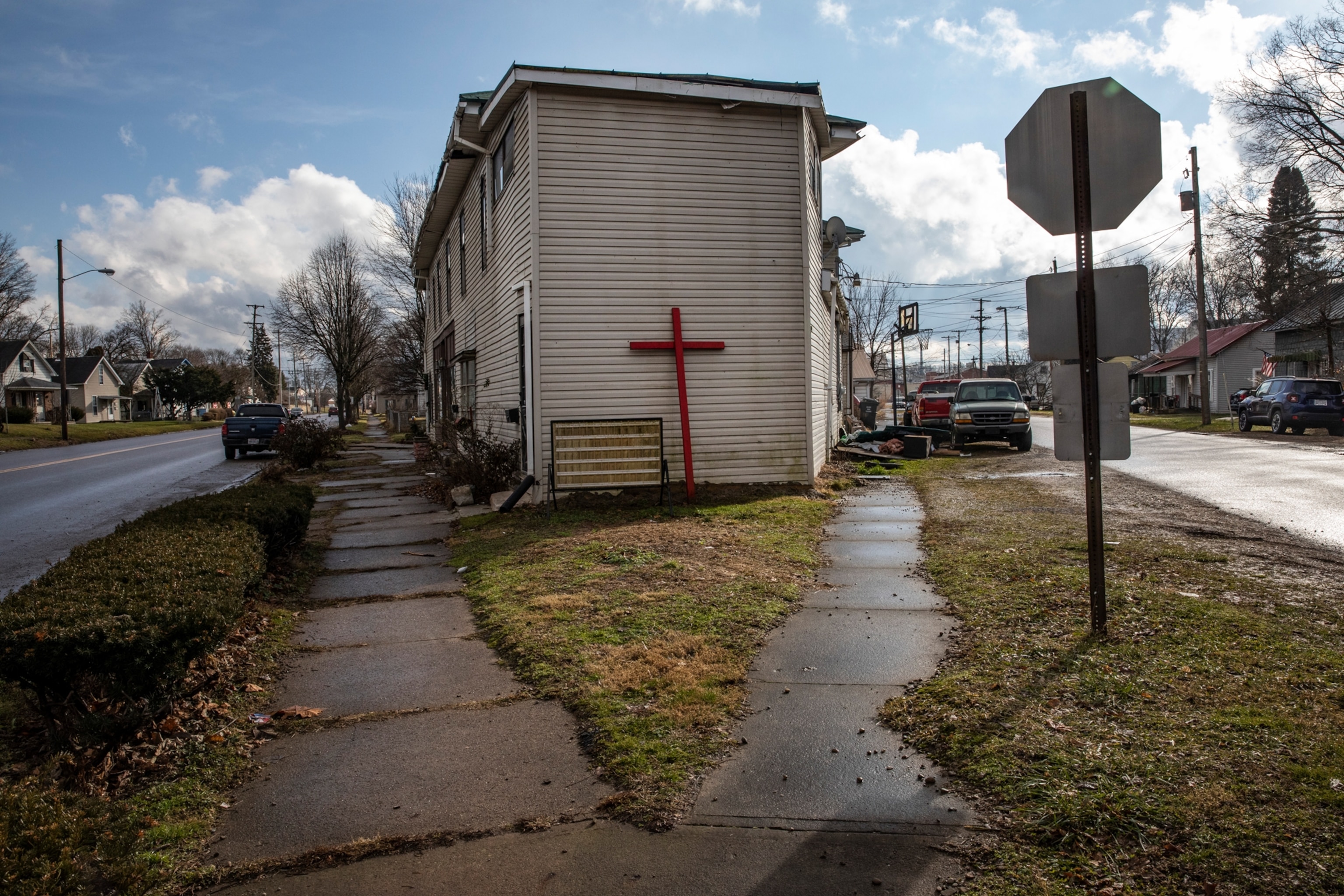 A Christian cross leans against a building