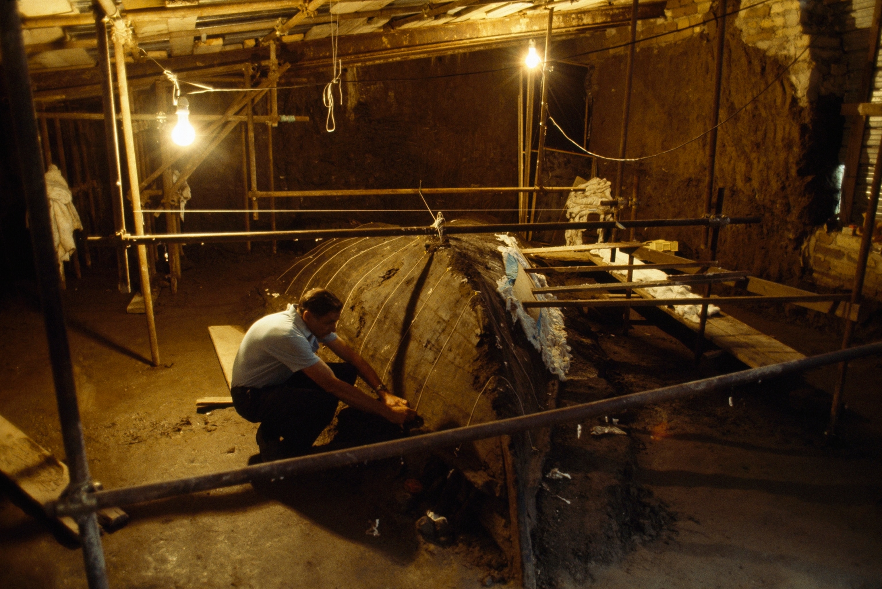 An archeologist examines a boat found at the ancient city Herculaneum.