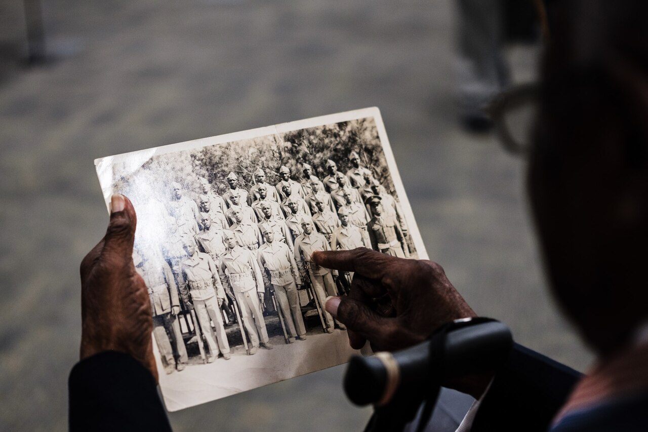 94 year old Montford Point Marine points at himself in an old portrait