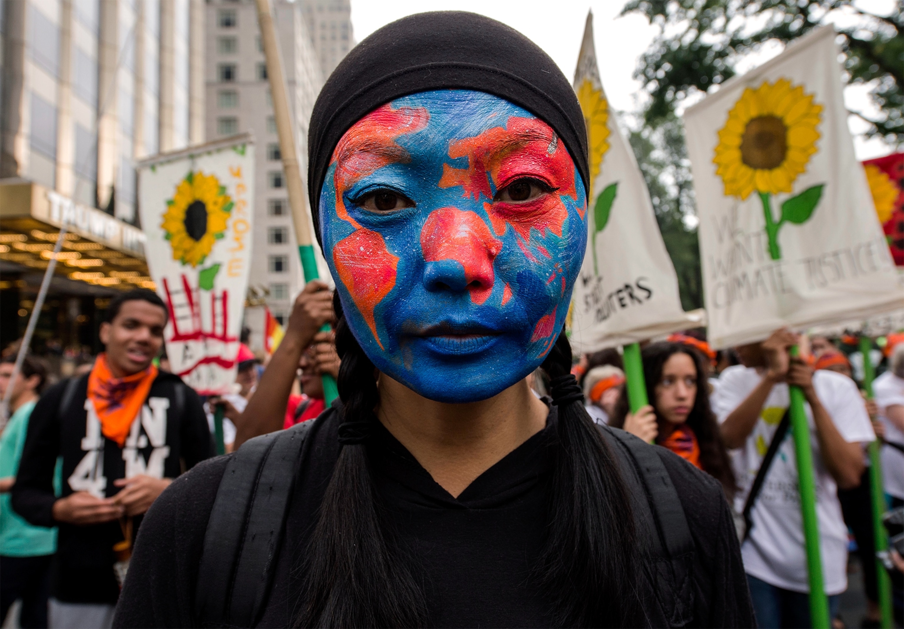 a girl with the earth painted on her face at the People's Climate March in New York