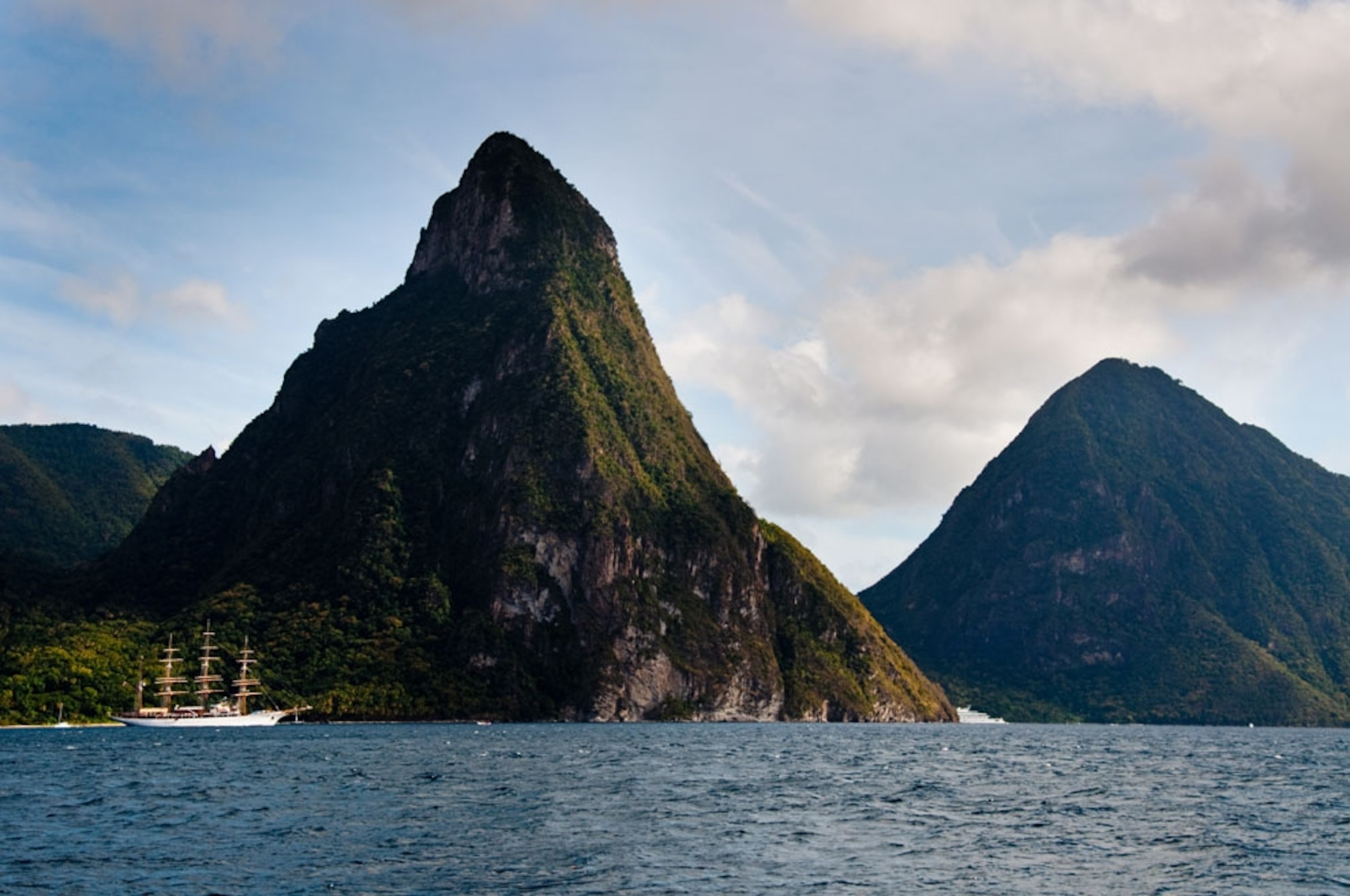 A sailboat crosses in front of The Pitons mountains on the island of Saint Lucia