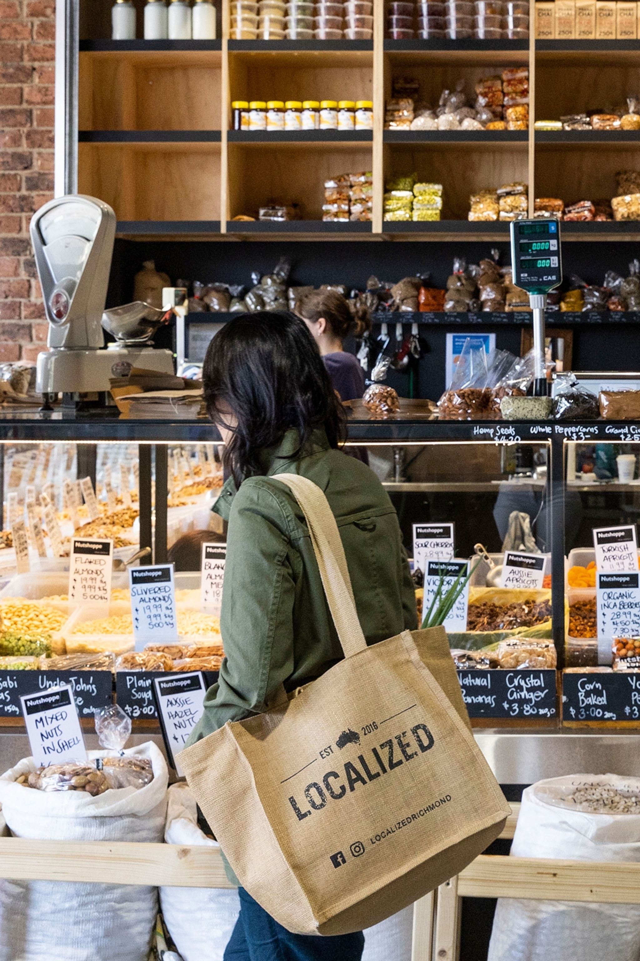 A woman browses a counter at an organic food shop.