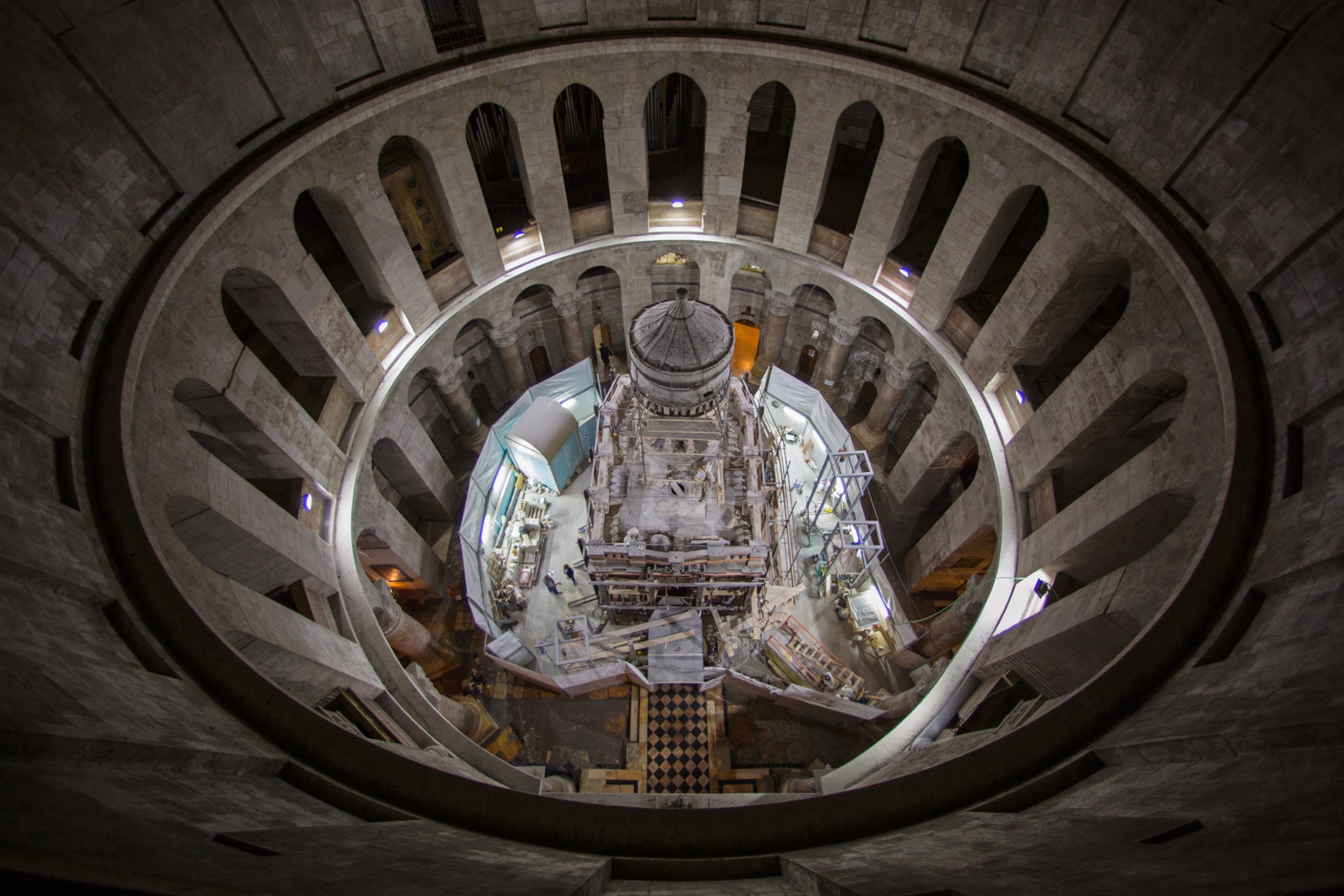 Top view of a circular, ancient stone church interior with a central dome, surrounded by arched columns.