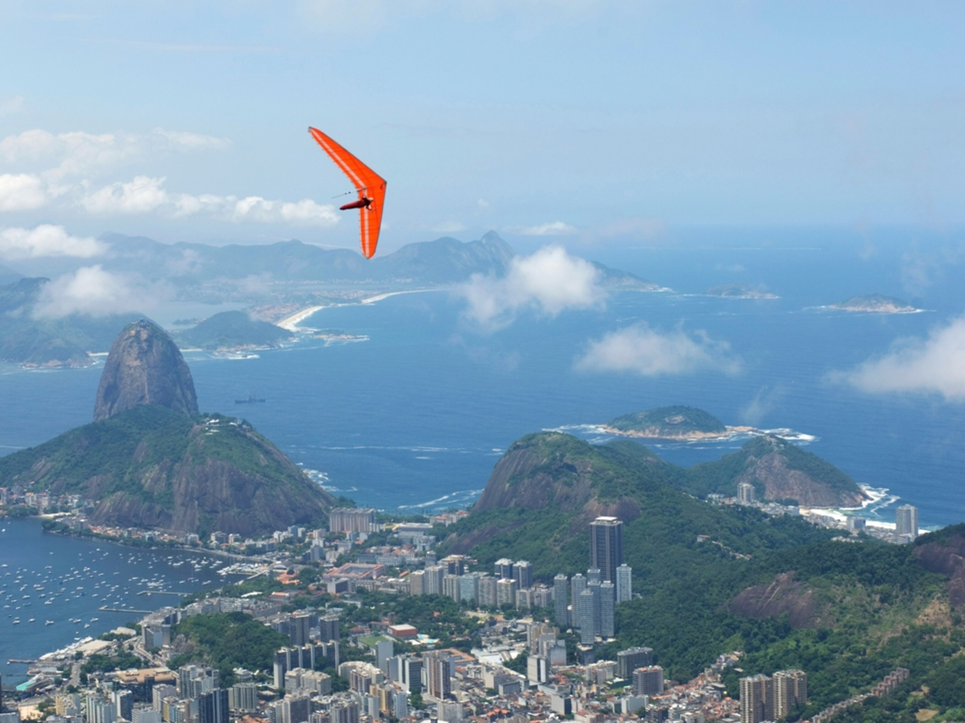 a hang glider over Rio De Janeiro with Sugarloaf mountain.