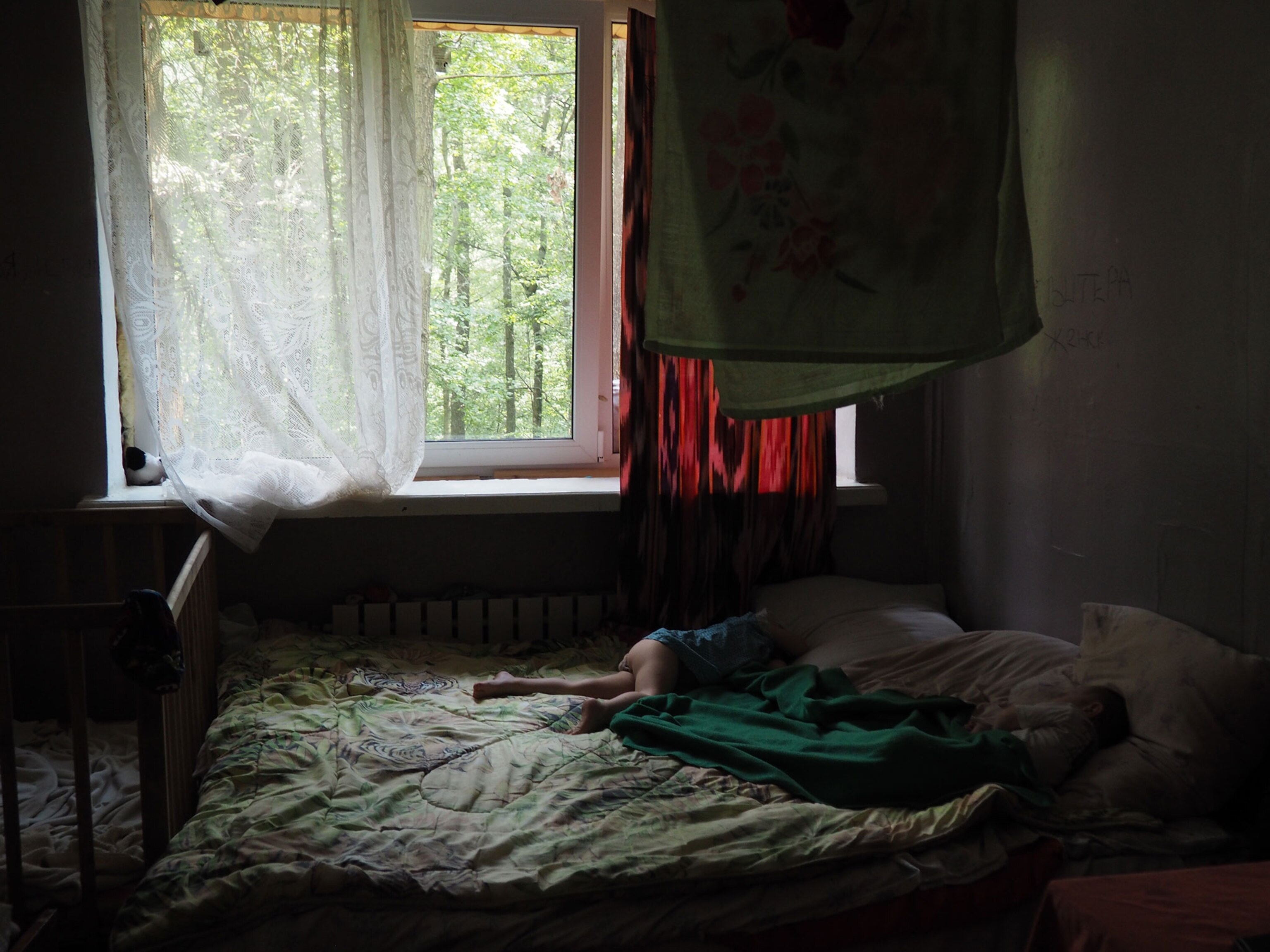 A little girl asleep on a bed in housing for IDPs in Ukraine