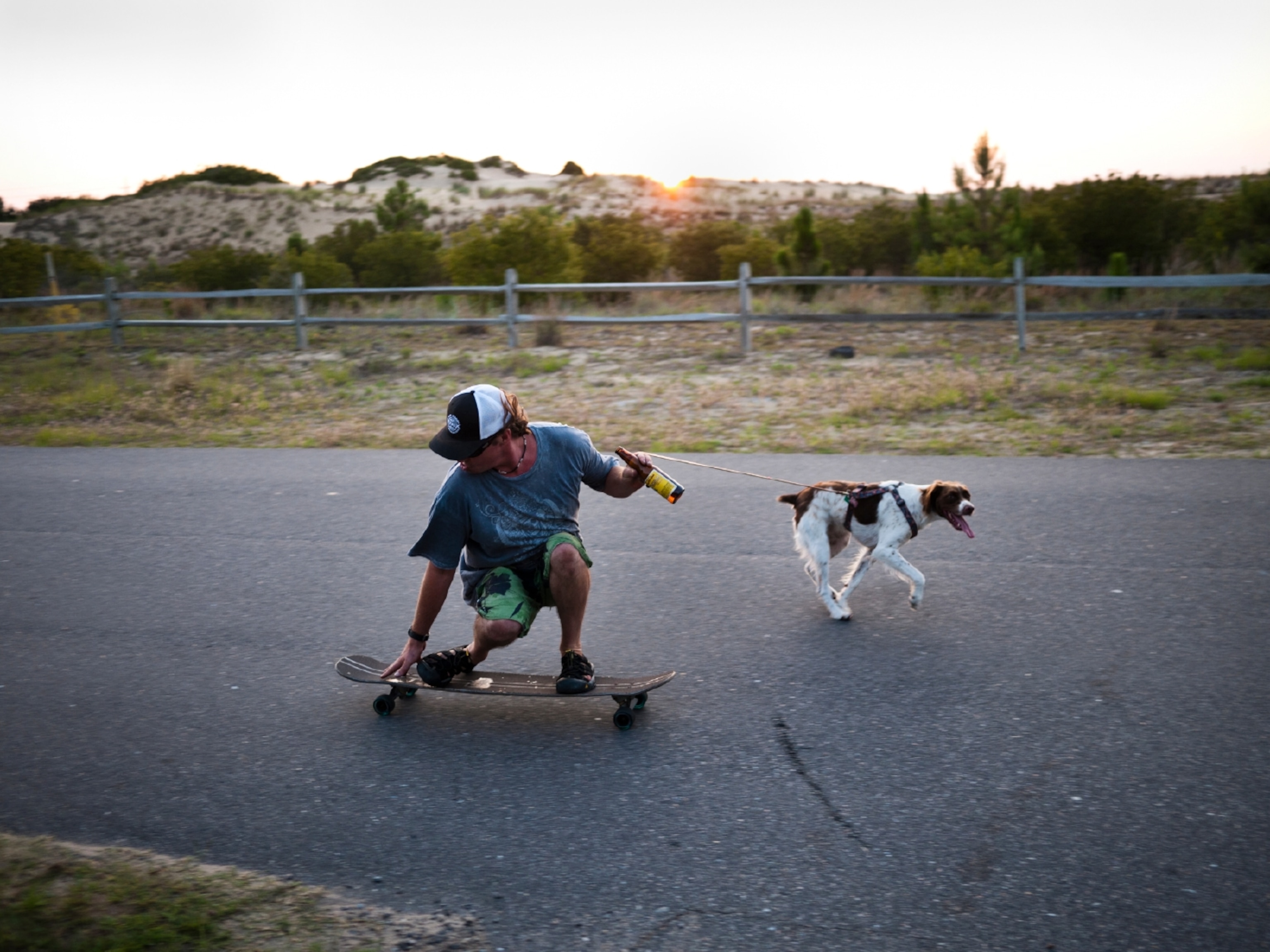 a Nags Head boy on a skateboard towed by a dog