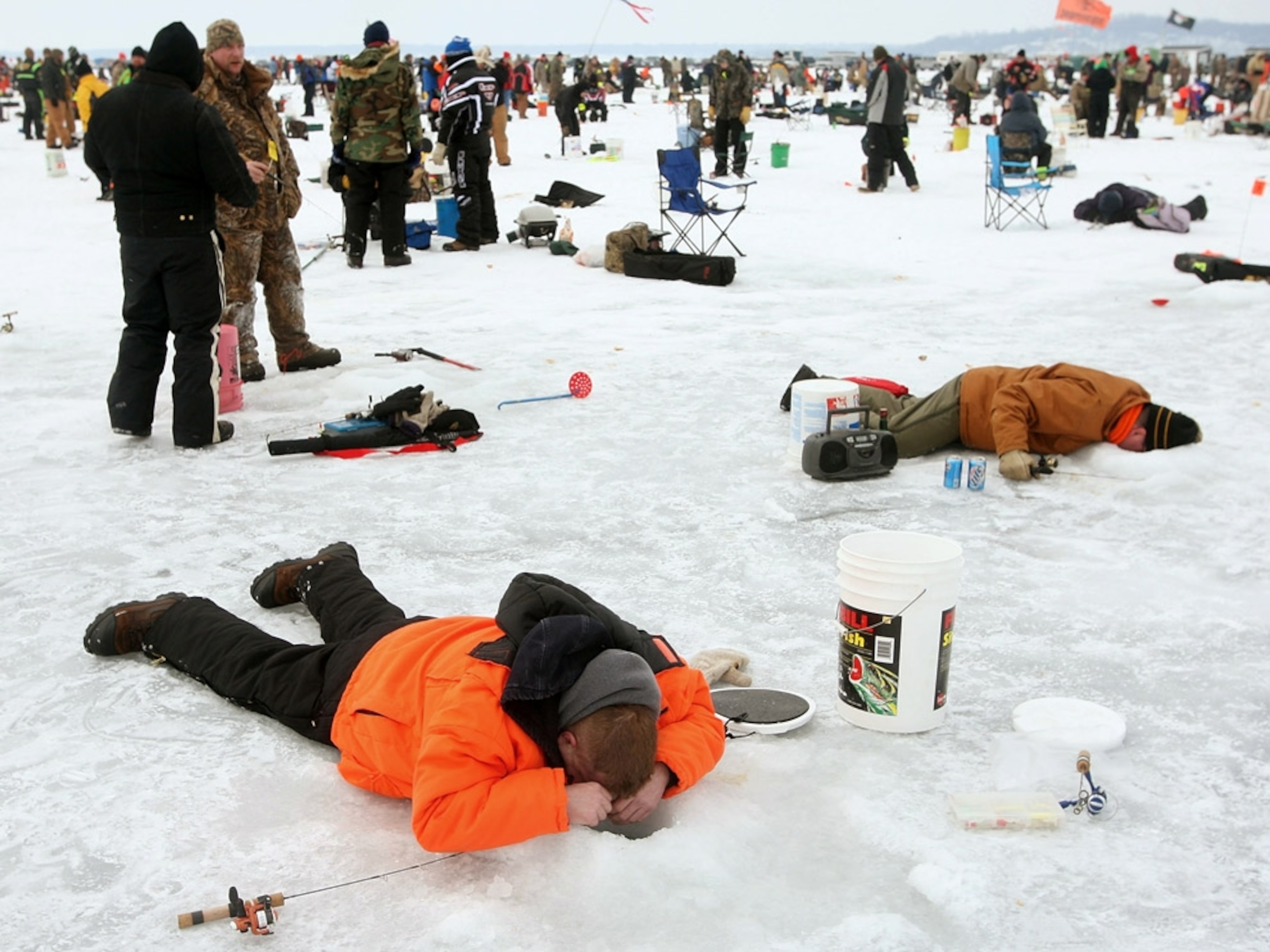 Fishermen looking through ice holes