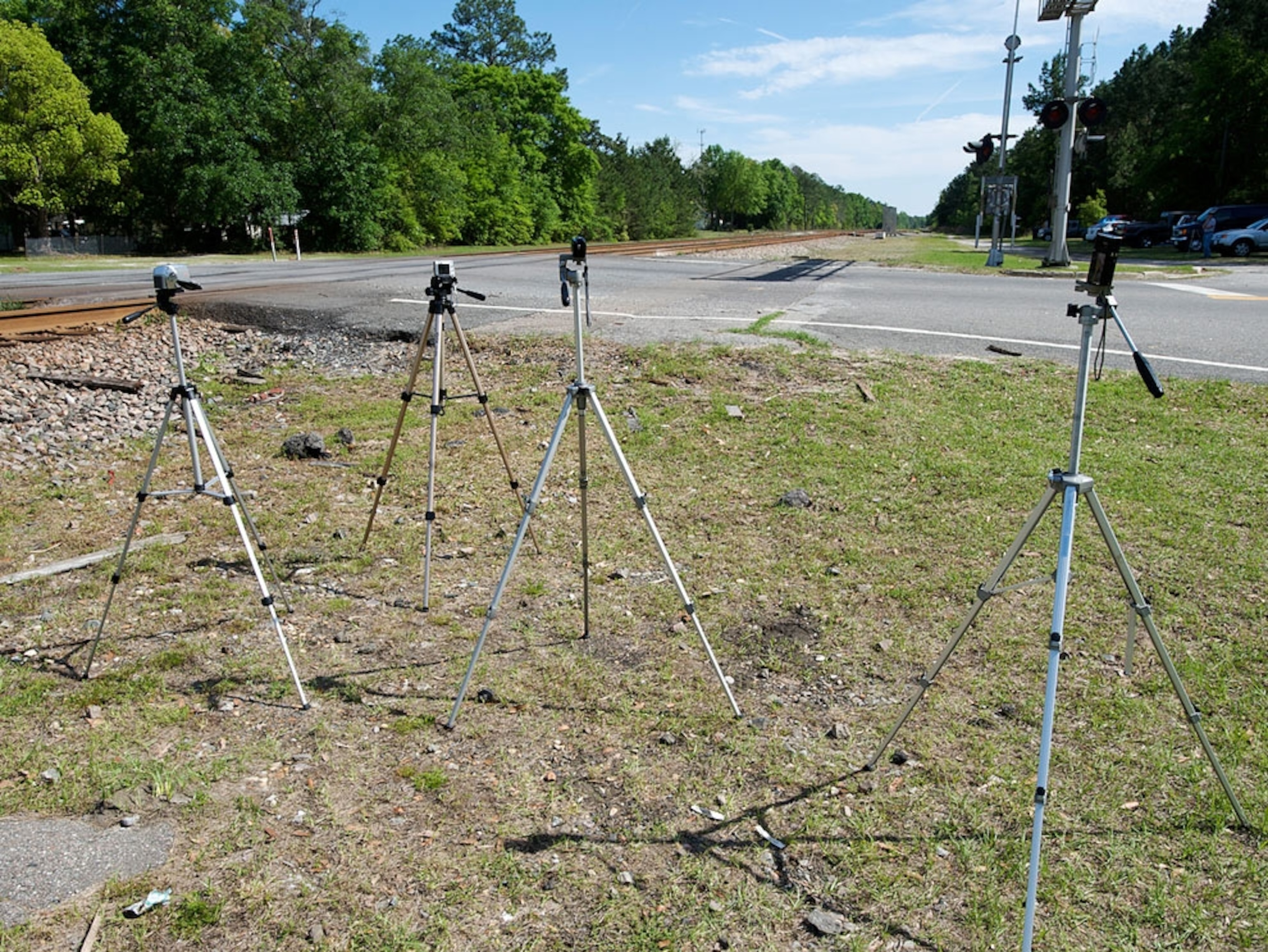 Four tripods set up near railroad tracks