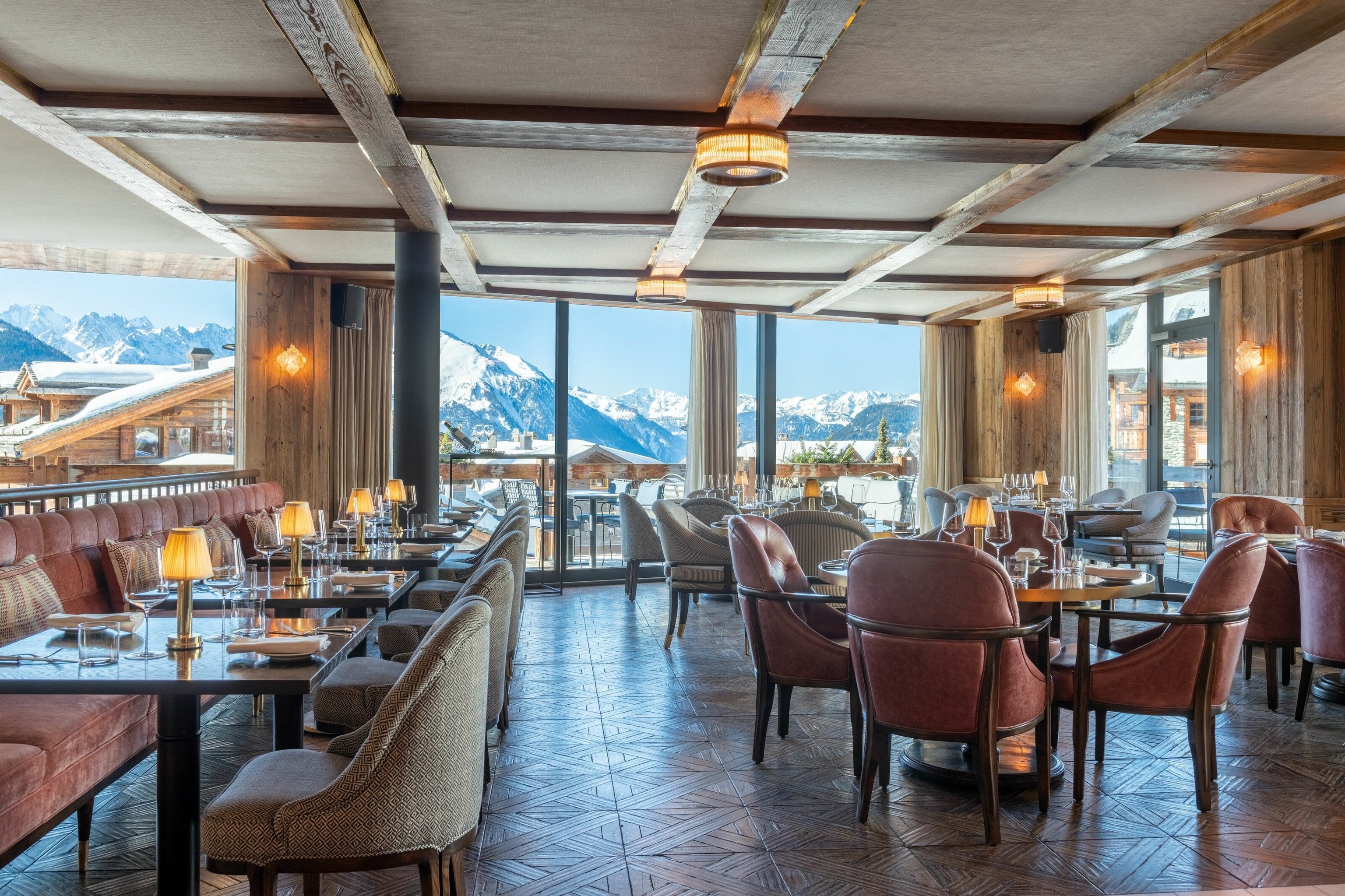 Restaurant with tables and chairs and view to the snowy mountains