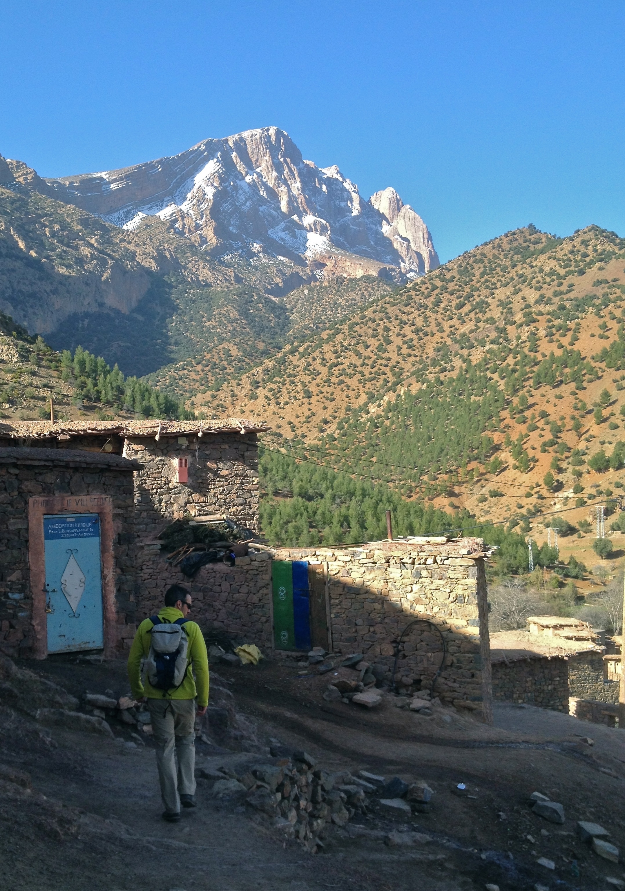 Kris leaving his village of Aguddim to explore with Jbel Aroudane in the distance; Photograph by Sam Elias