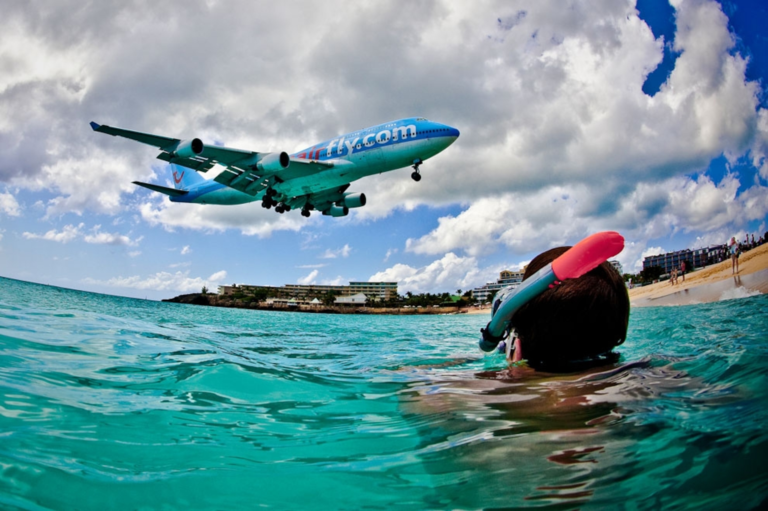 A Jumbo jet comes in for landing above a snorkeler in the Caribbean