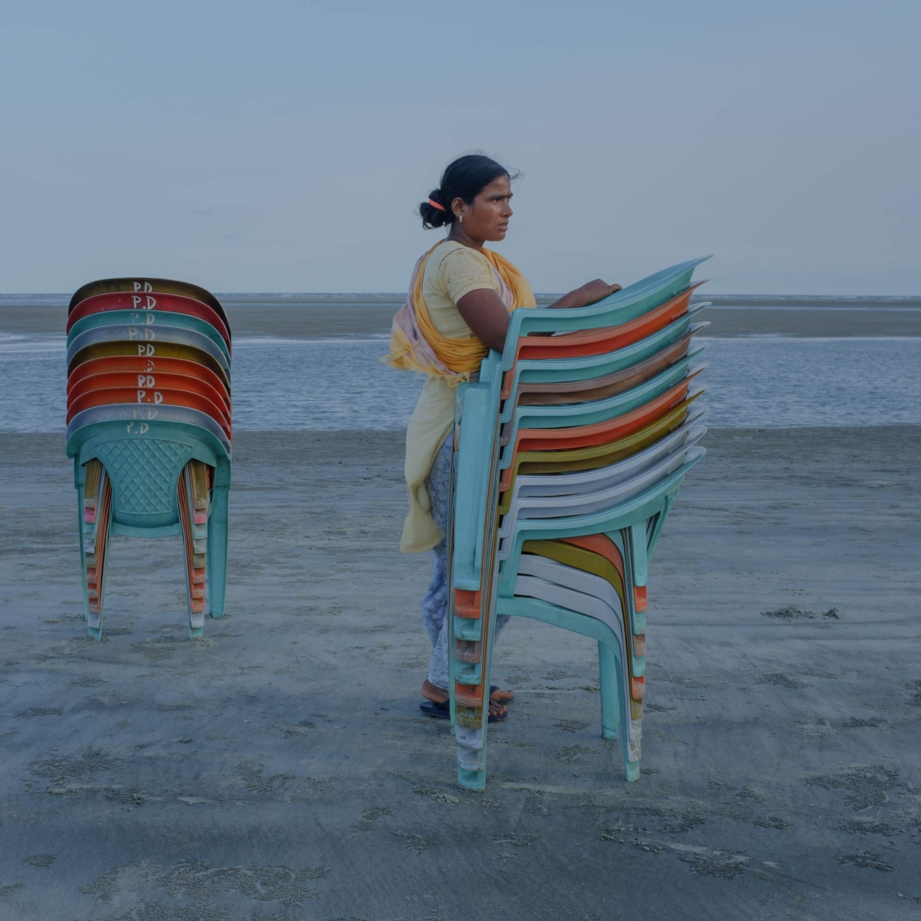 A woman waits for tourists on the beach in West Bengal