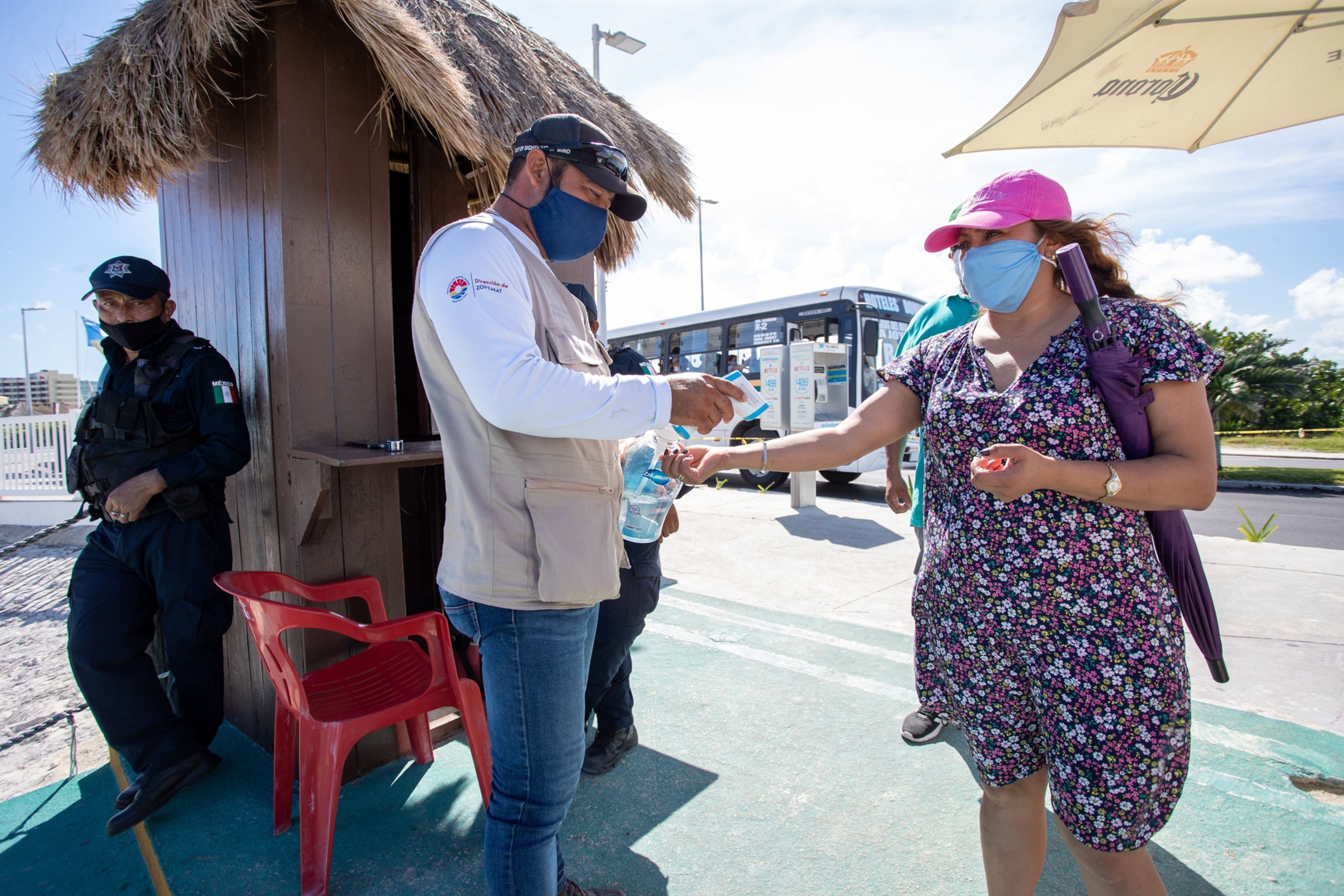 a tourist gets her temperature taken in cancun, mexico
