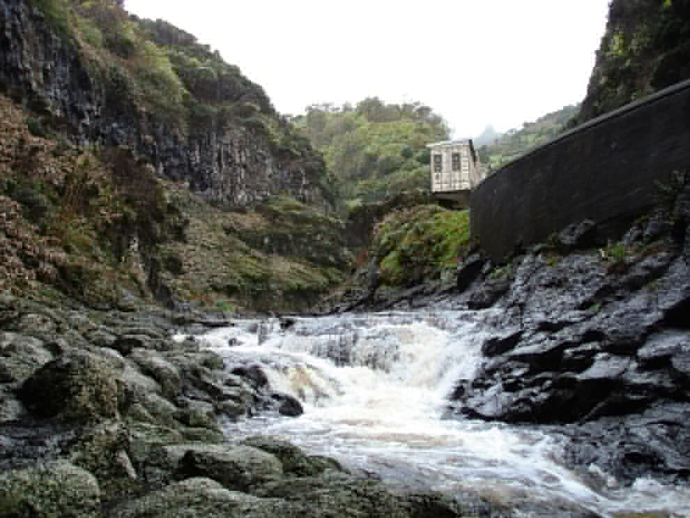 A flywheel building and waterfall on the island of Flores